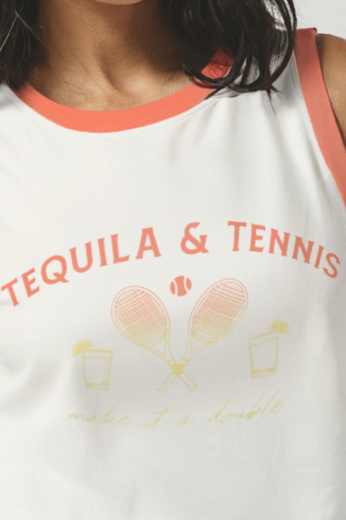 Close up of woman wearing a white tank top with &