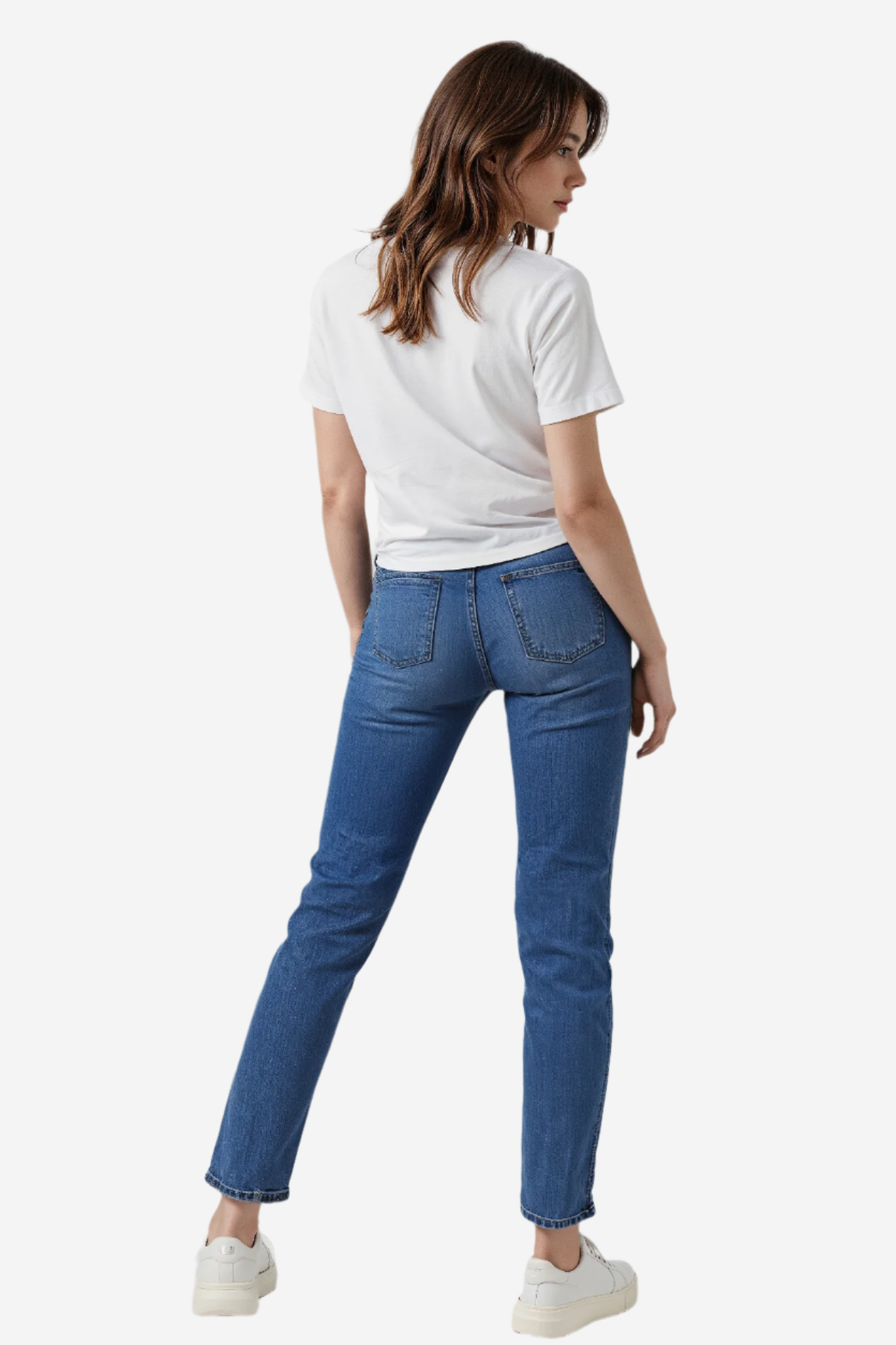Woman wearing a white t-shirt and blue jeans on a plain background