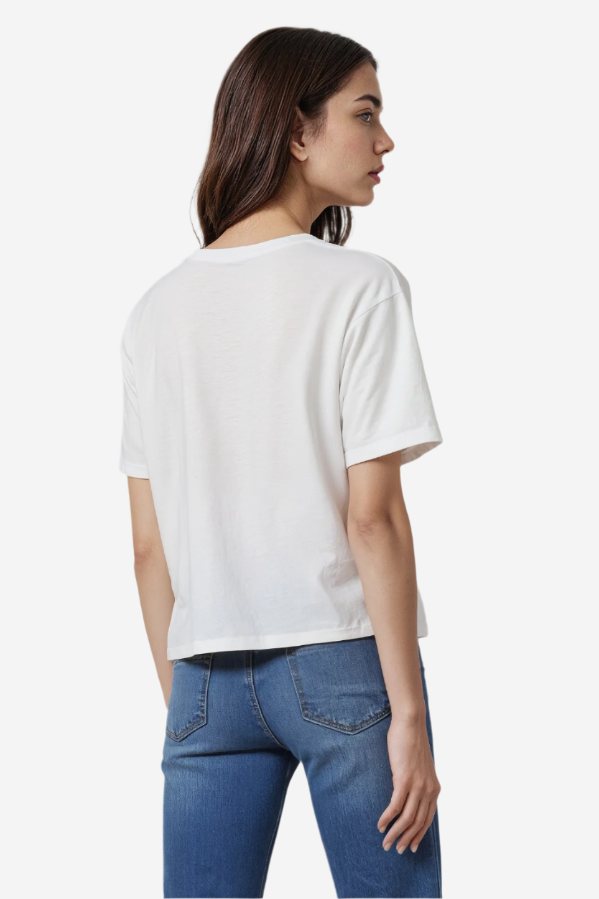 Woman wearing a white t-shirt and blue jeans on a plain background