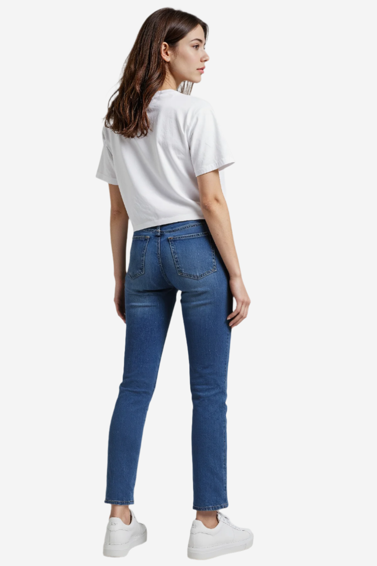 Woman wearing a white t-shirt and blue jeans on a plain background