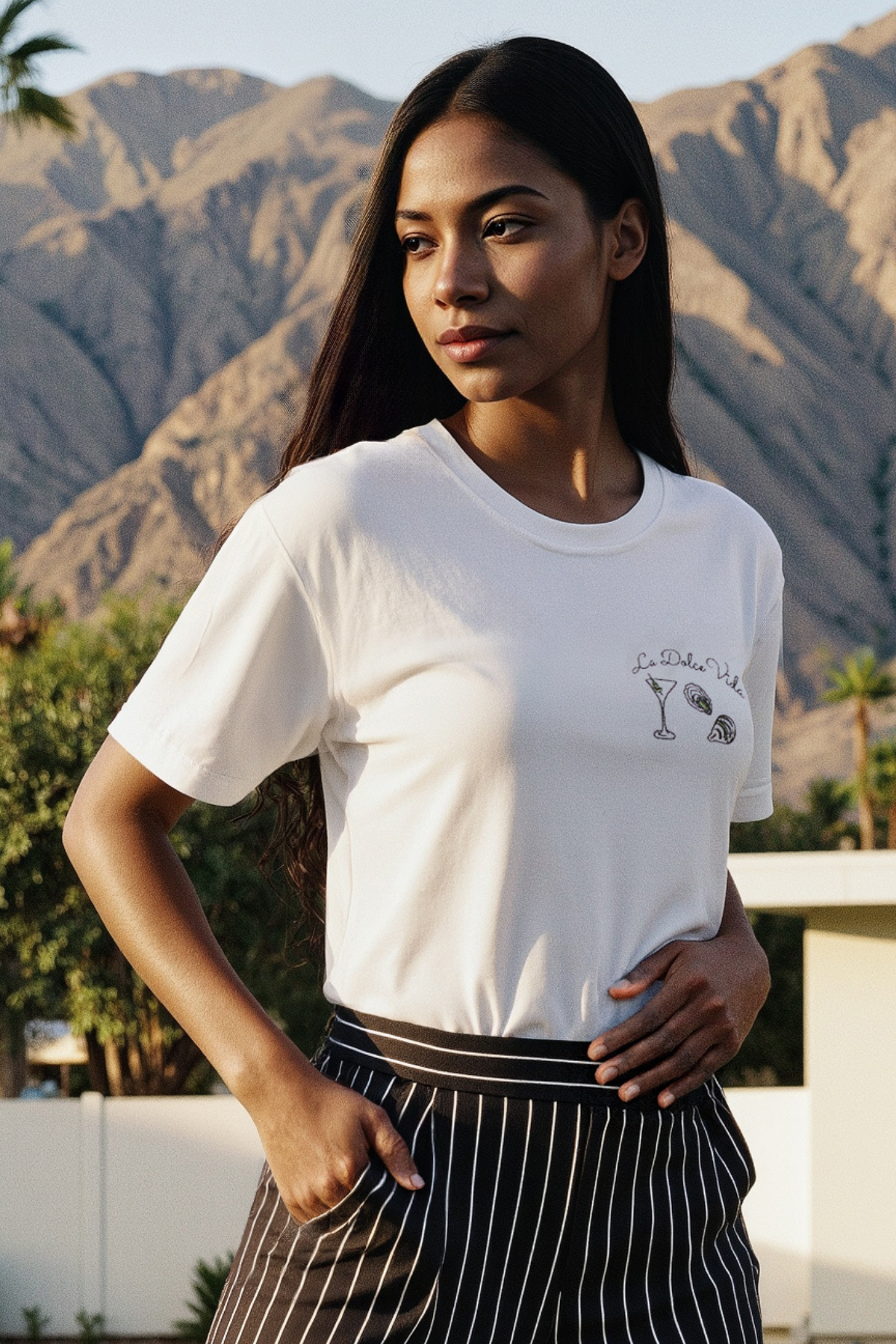 A woman wearing a white crop tee with the text &