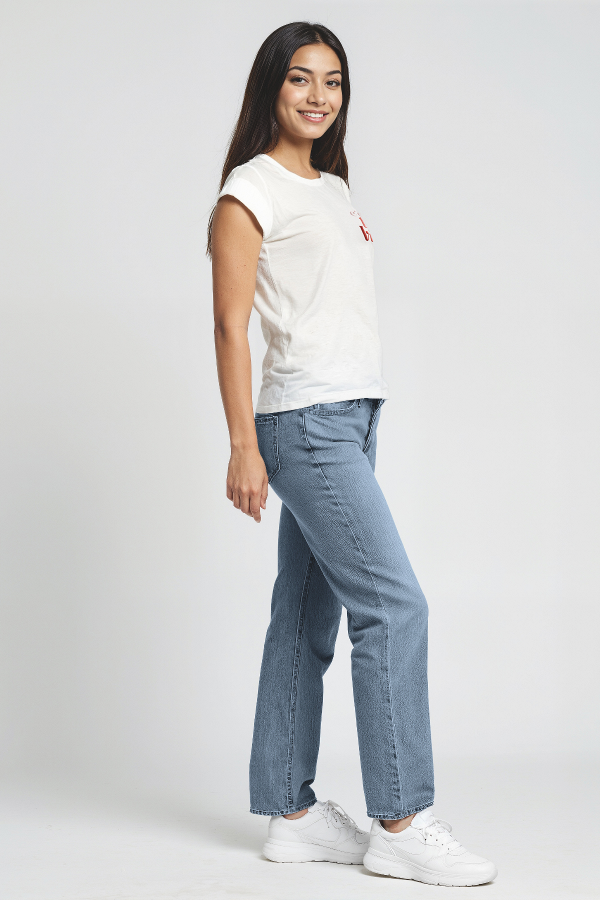 Woman wearing a white t-shirt with a "Cest La Vie" test and blue jeans on a white background