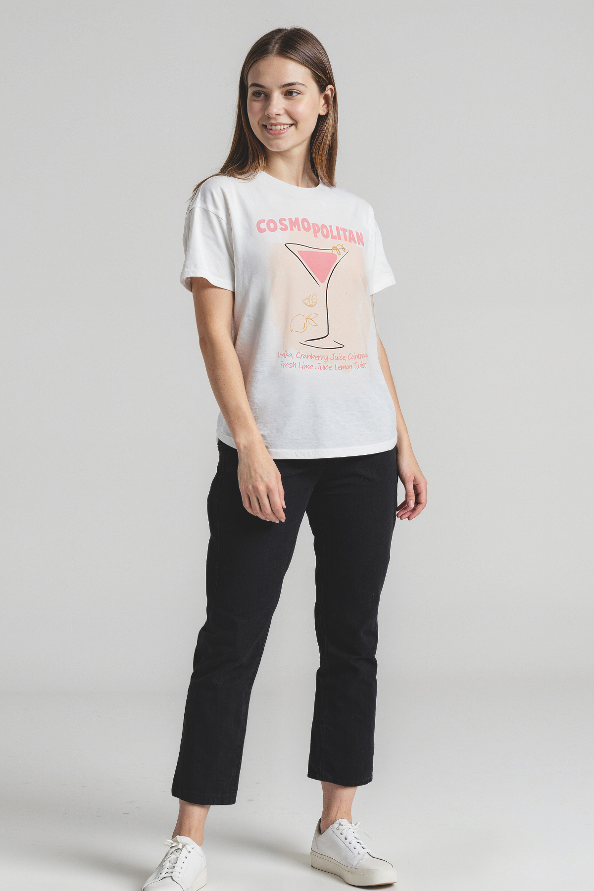 Woman wearing a white t-shirt with a graphic design on a plain background