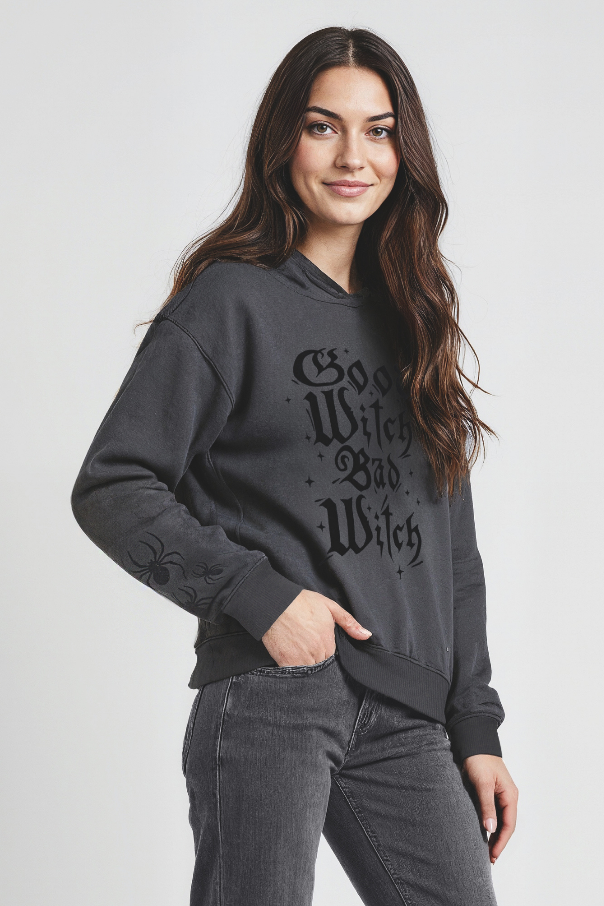 Woman wearing a dark gray hoodie with text on a plain background