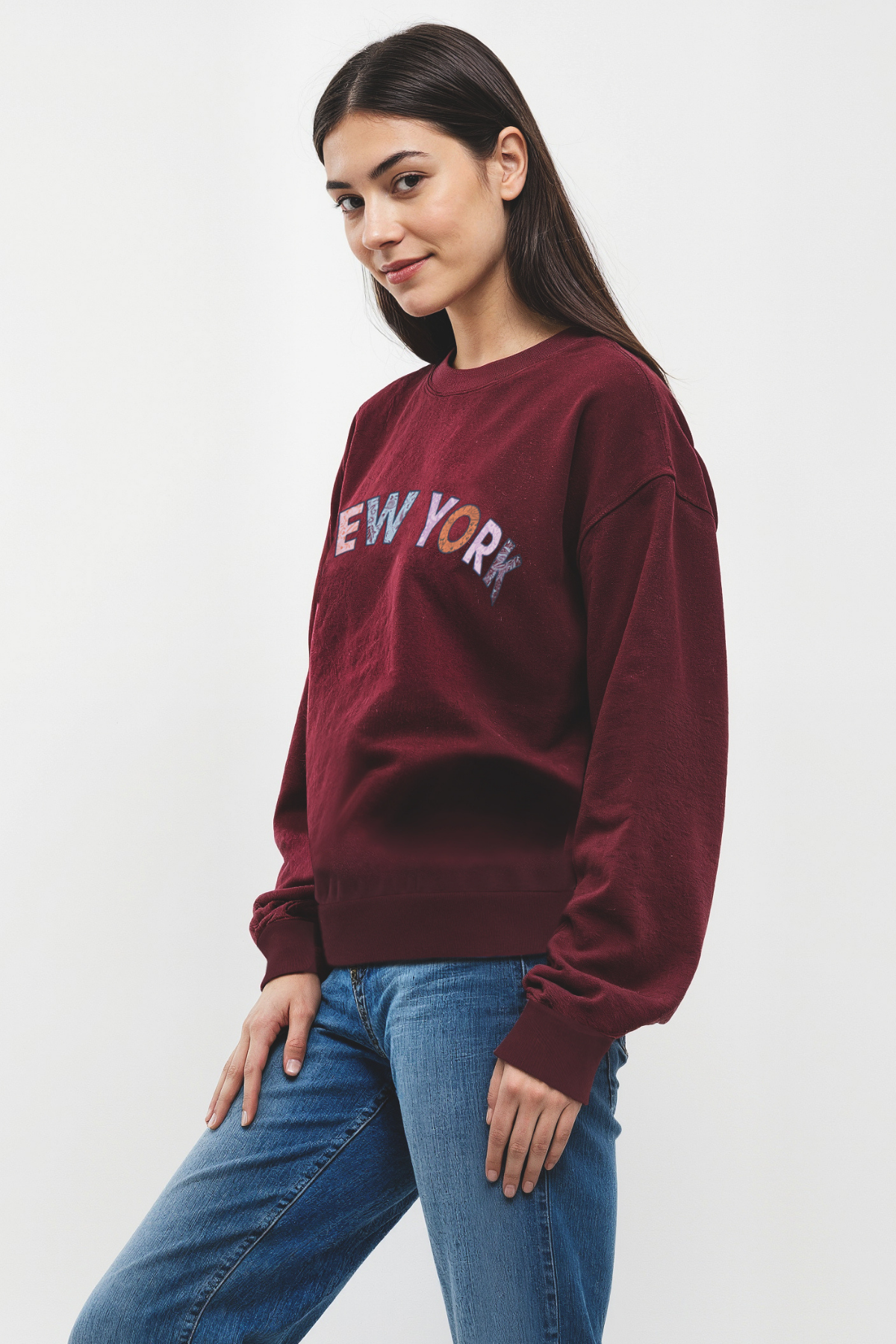 Woman wearing a maroon sweatshirt with &