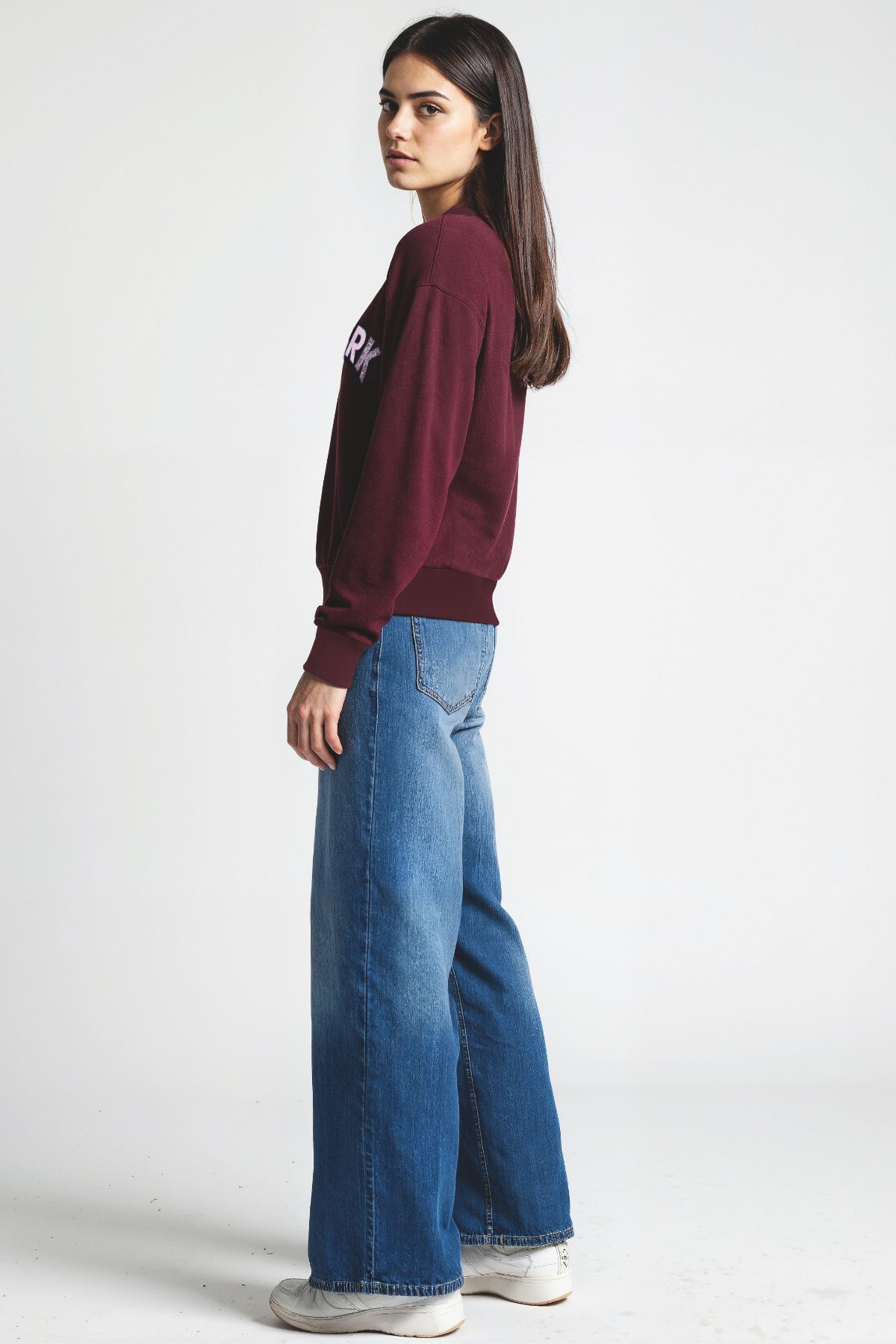 Woman wearing a maroon sweatshirt with &