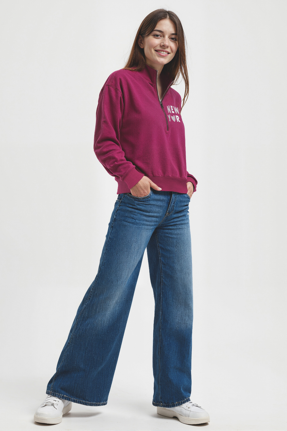 Woman wearing a magenta 1/2 zip pullover with &