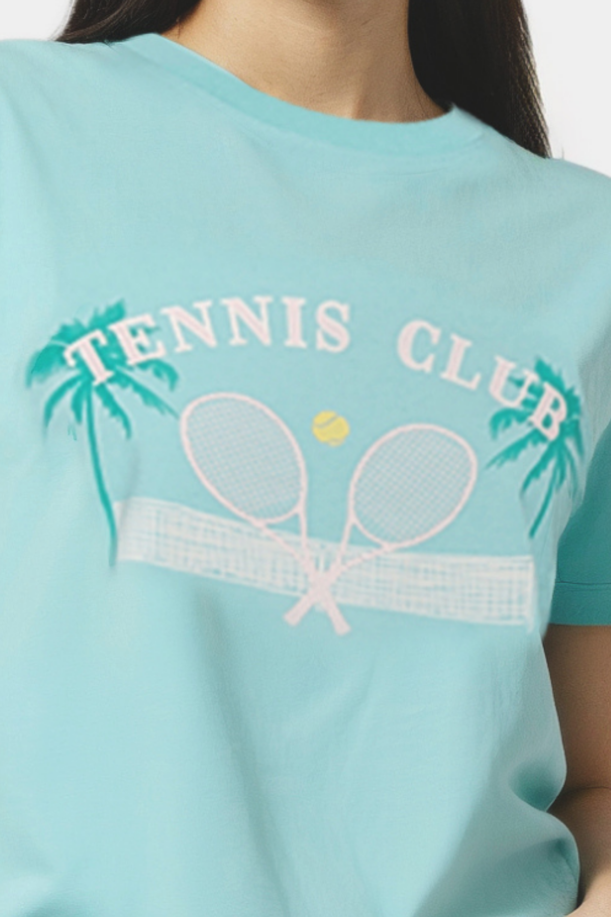 Closeup of woman wearing a light teal blue t-shirt with &