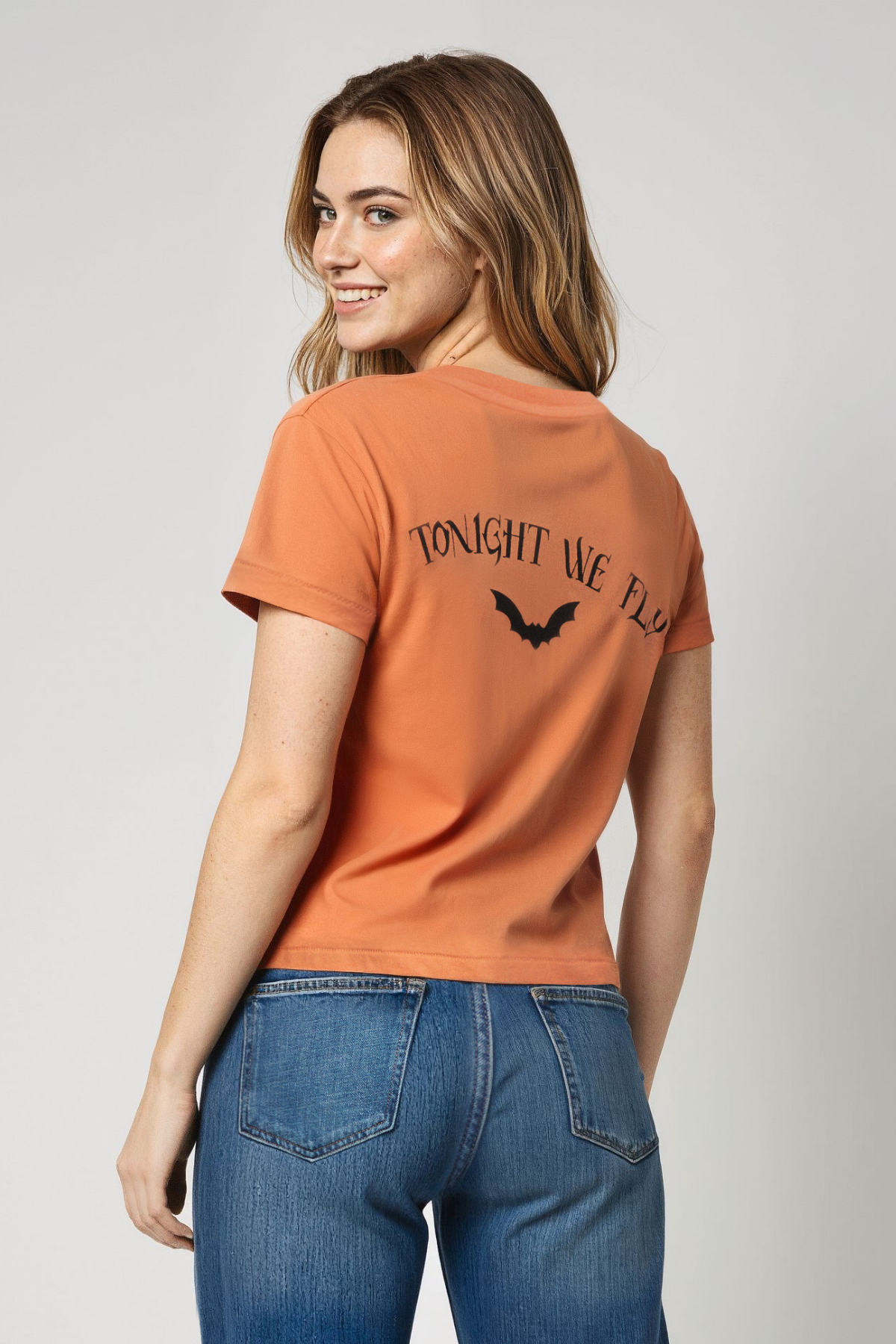 Woman wearing an orange t-shirt with &