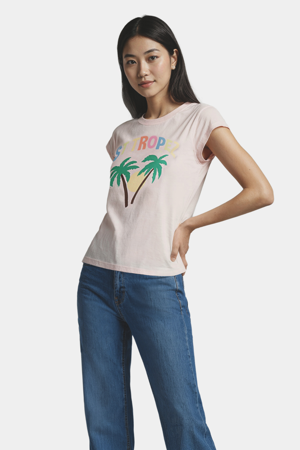 Woman wearing a pink t-shirt with palm trees and sun design and &