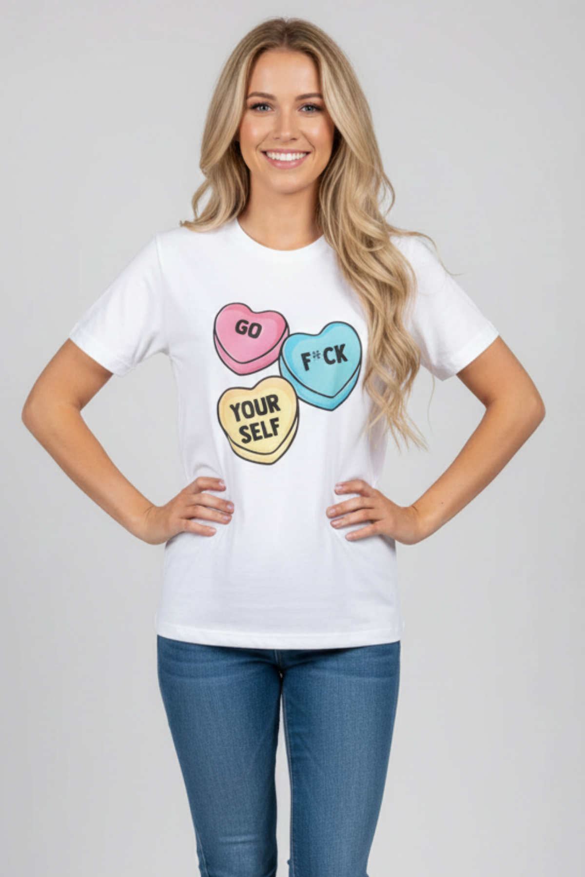 Woman wearing a white crew neck t-shirt with graphic candy hearts and "Go F*ck Yourself" text printed on the front.