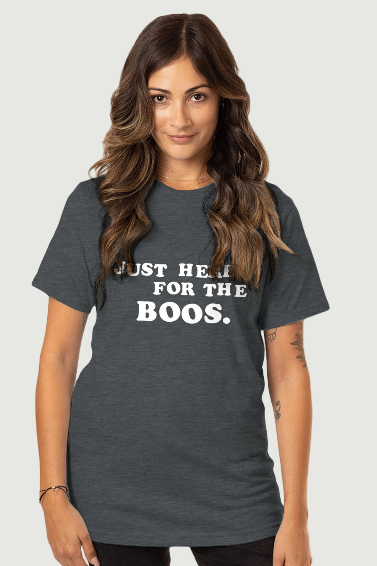 A woman wearing a gray crew neck t-shirt with the white text &