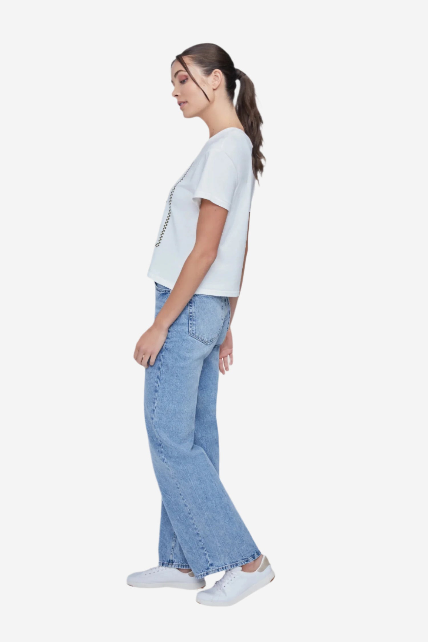 A woman wearing a white crop top with a martini glass graphic and text that includes &