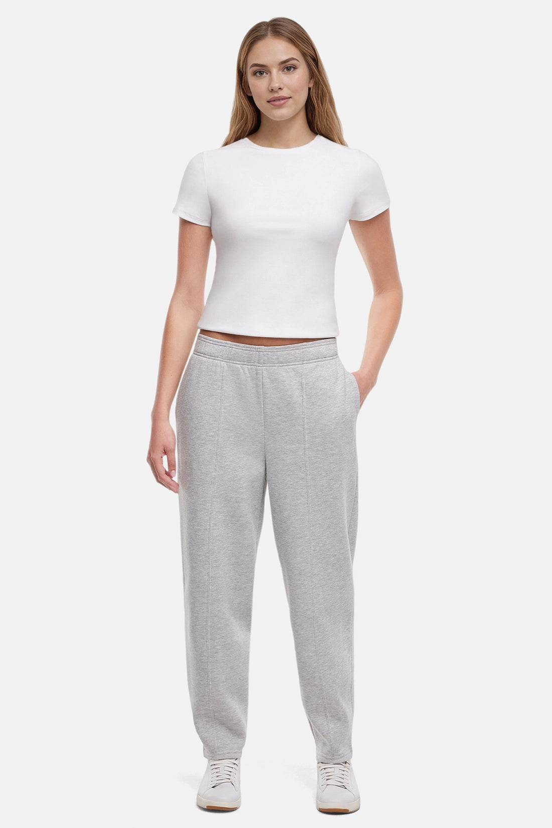 Woman wearing a white t-shirt and heather grey tapered leg pants on a white background
