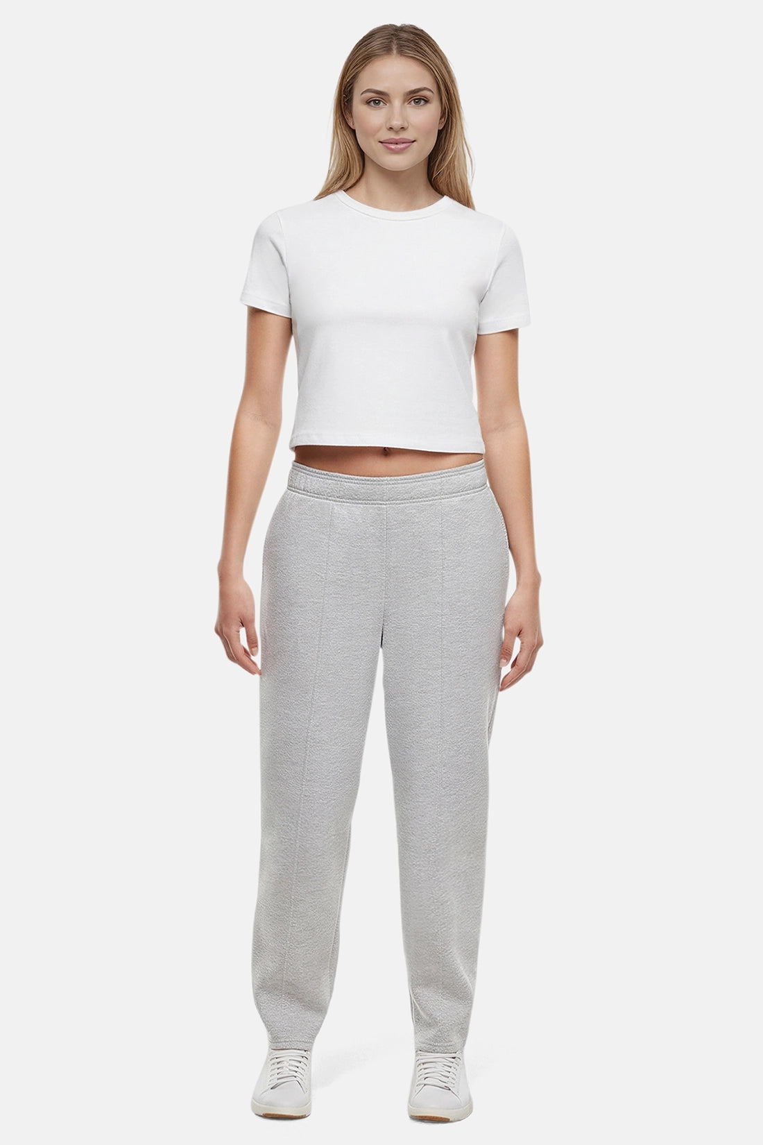 Woman wearing a white t-shirt and heather grey tapered leg pants on a white background
