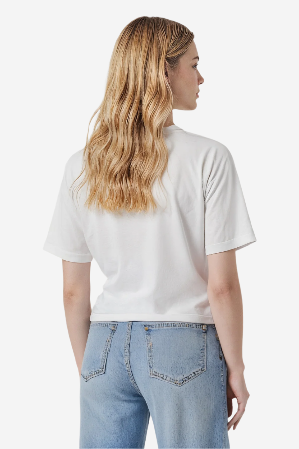 Woman wearing a white t-shirt and blue jeans on a plain background