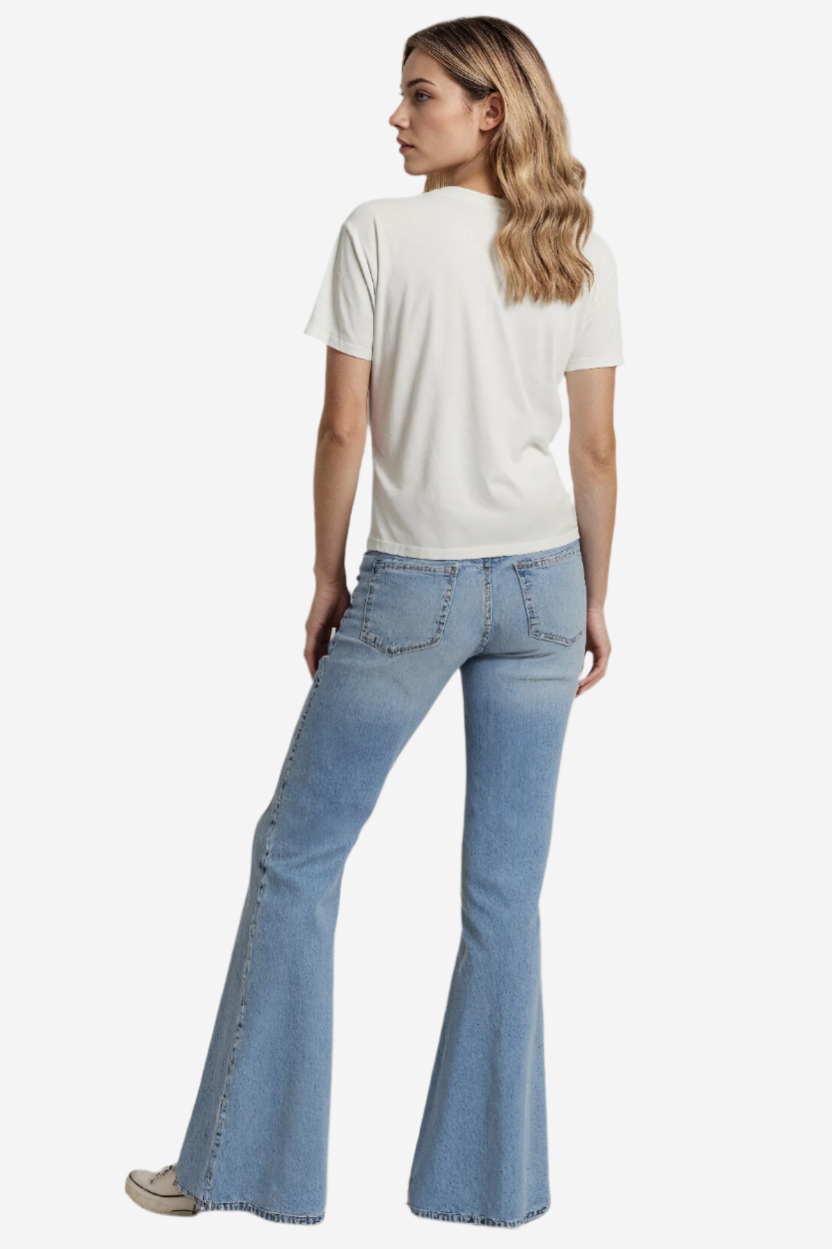 Back of woman wearing a white t-shirt and blue jeans on a plain background.