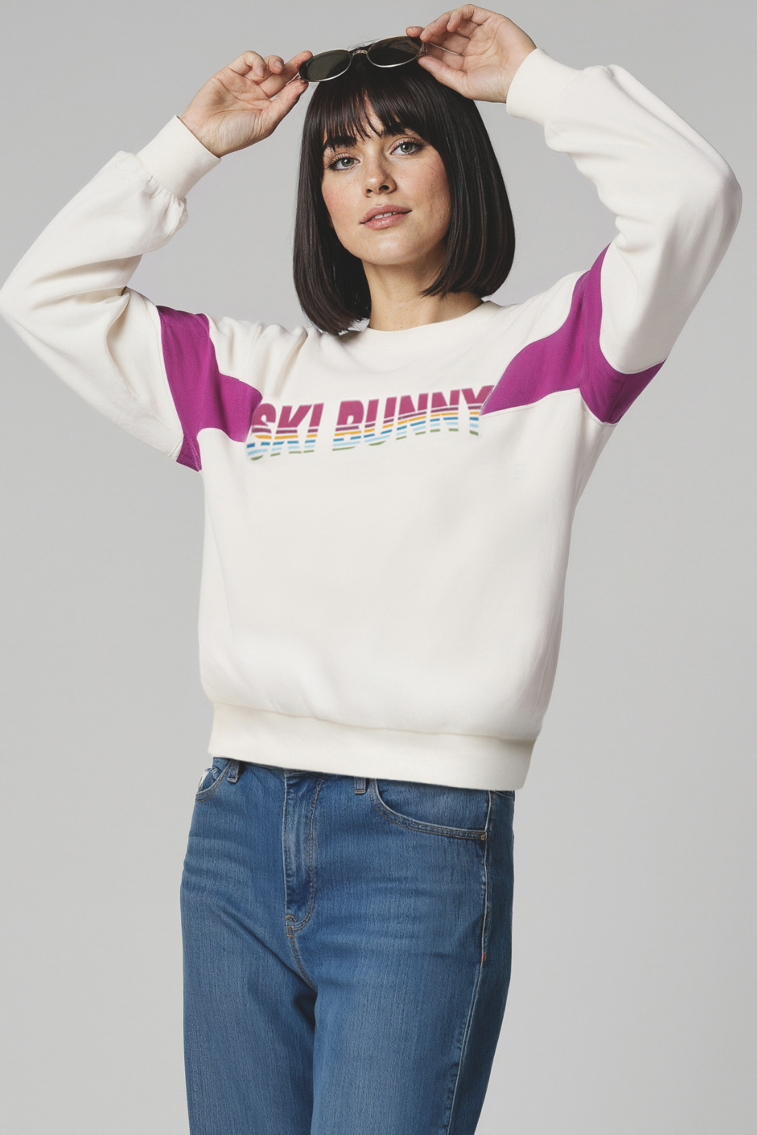 Woman wearing a white sweatshirt with colorful &