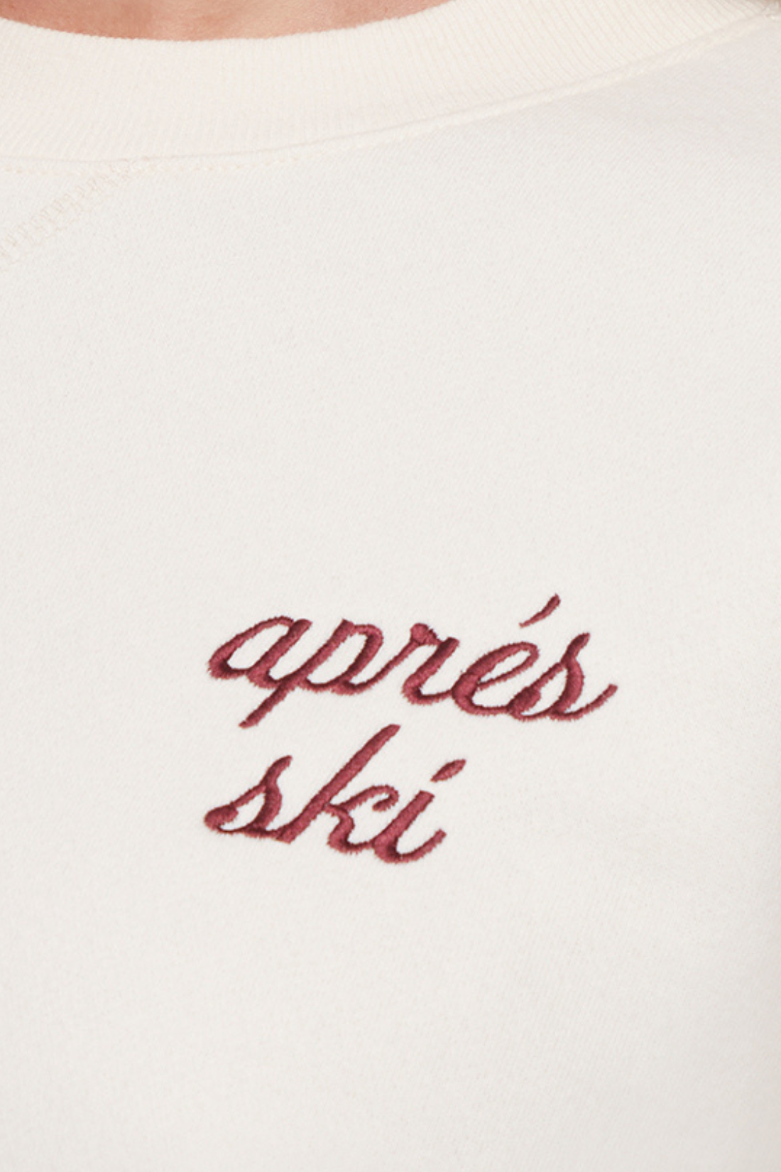 Close up of white sweatshirt with red &