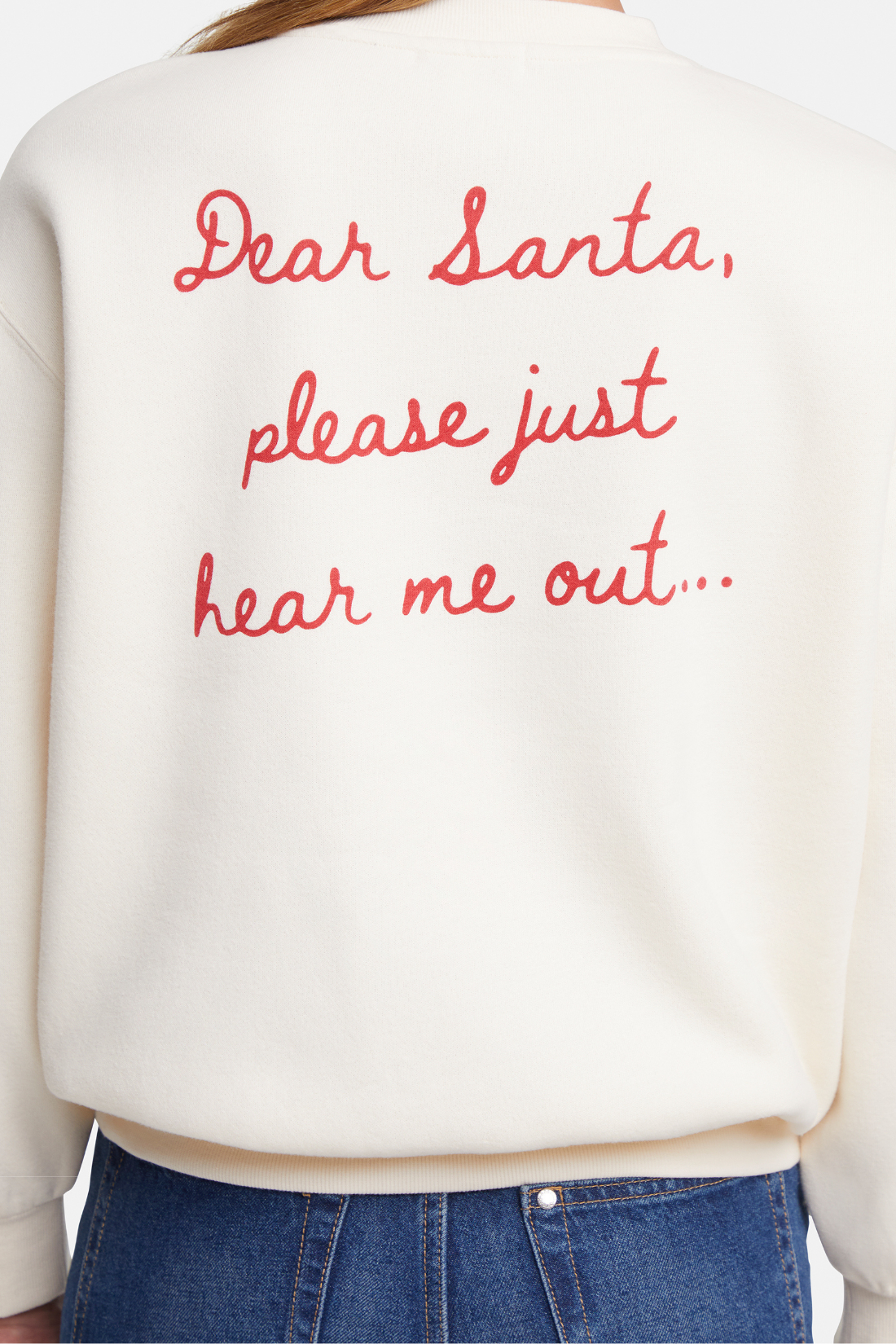 Close up of white sweater with red text &