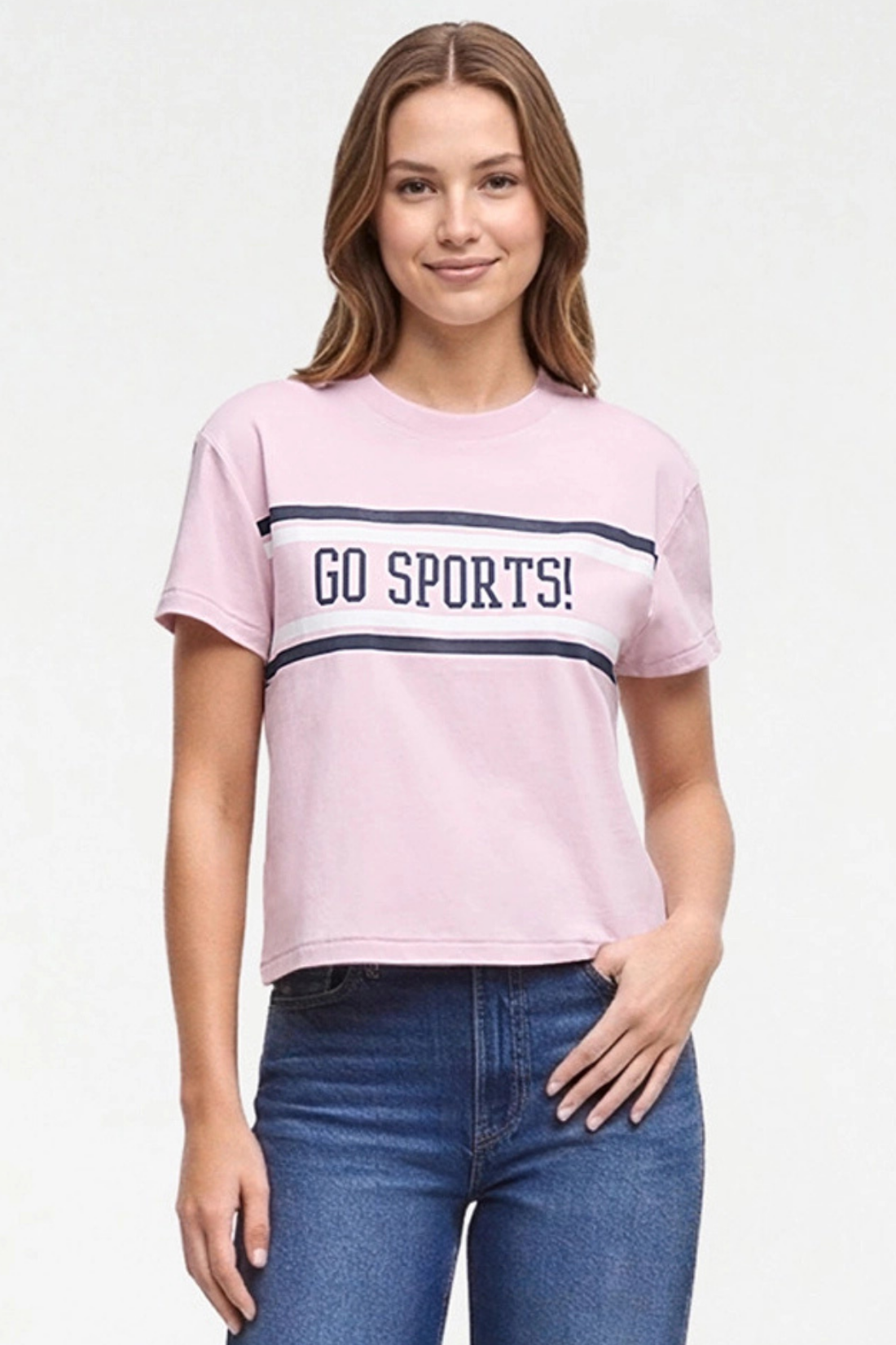 A woman wearing a light pink short-sleeve t-shirt with navy blue stripes and the text &