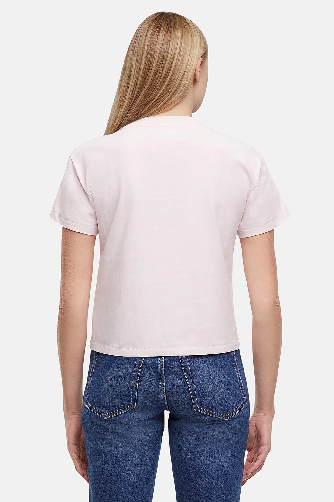 Back of woman wearing a light pink t-shirt and blue jeans on a white background