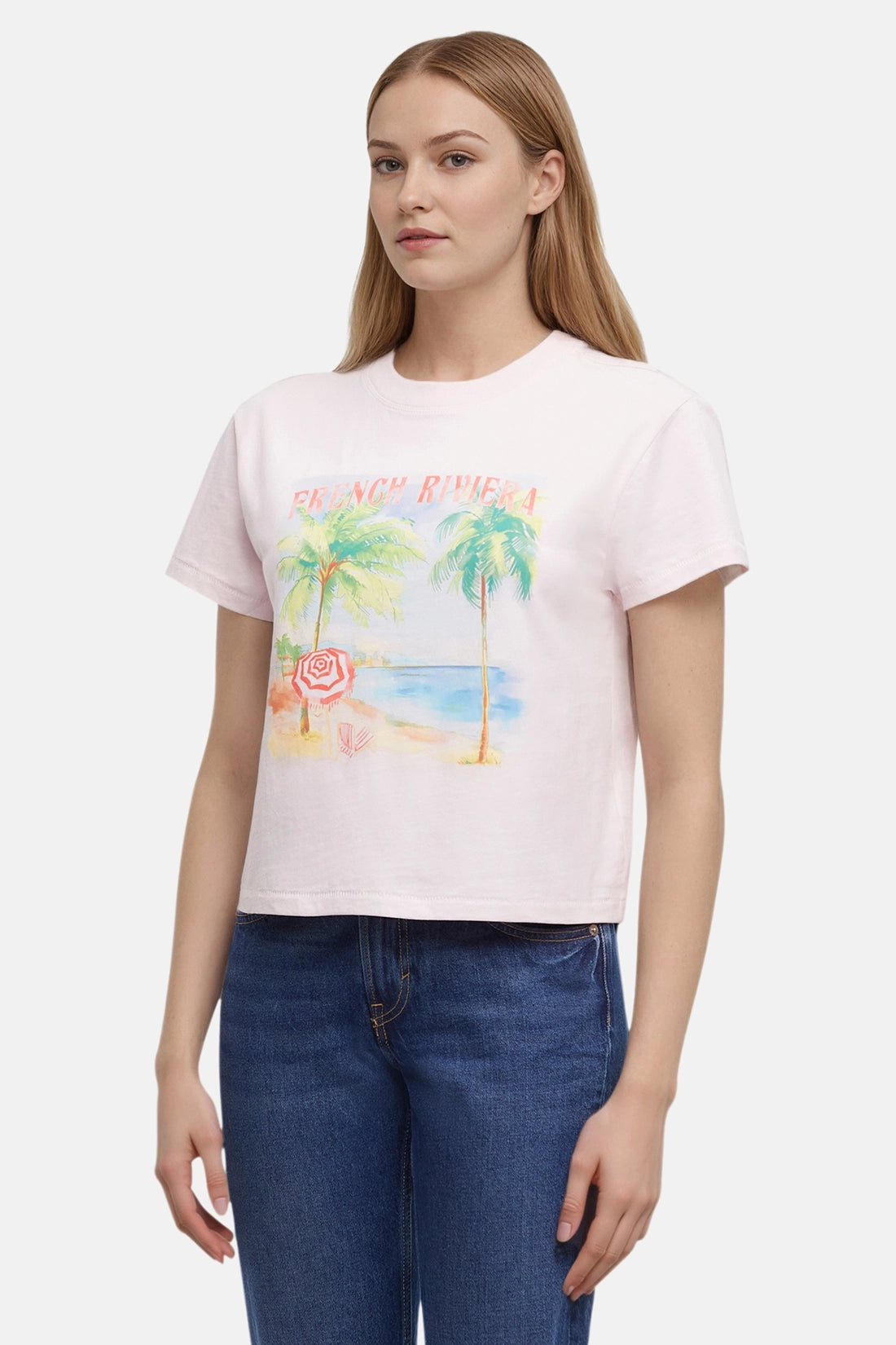 Woman wearing a pink t-shirt with a beach graphic and &