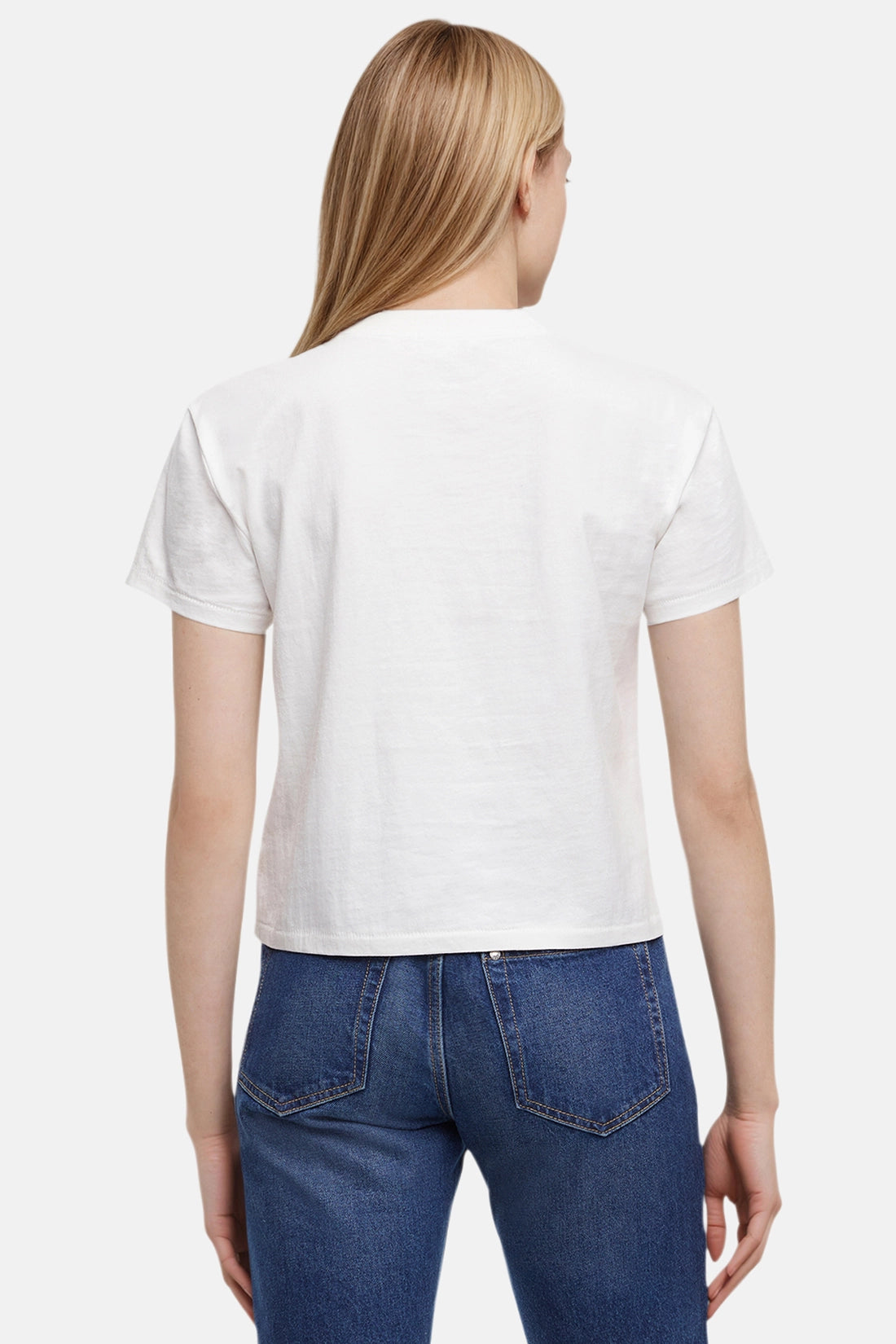 Back of woman wearing a white t-shirt and blue jeans on a plain background