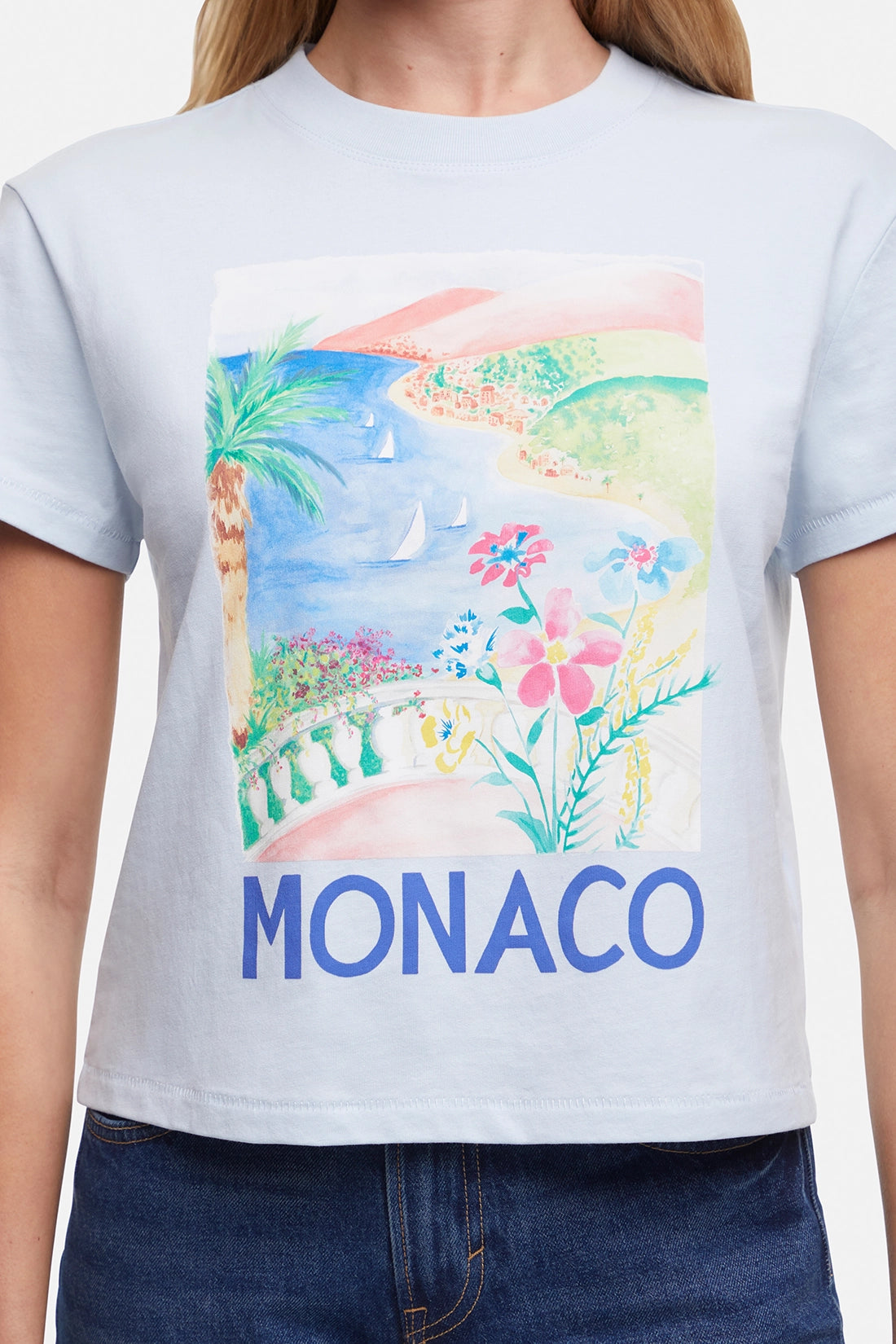 Close up of T-shirt with a colorful beach, flowers, & sailboats graphic of Monaco and the word &