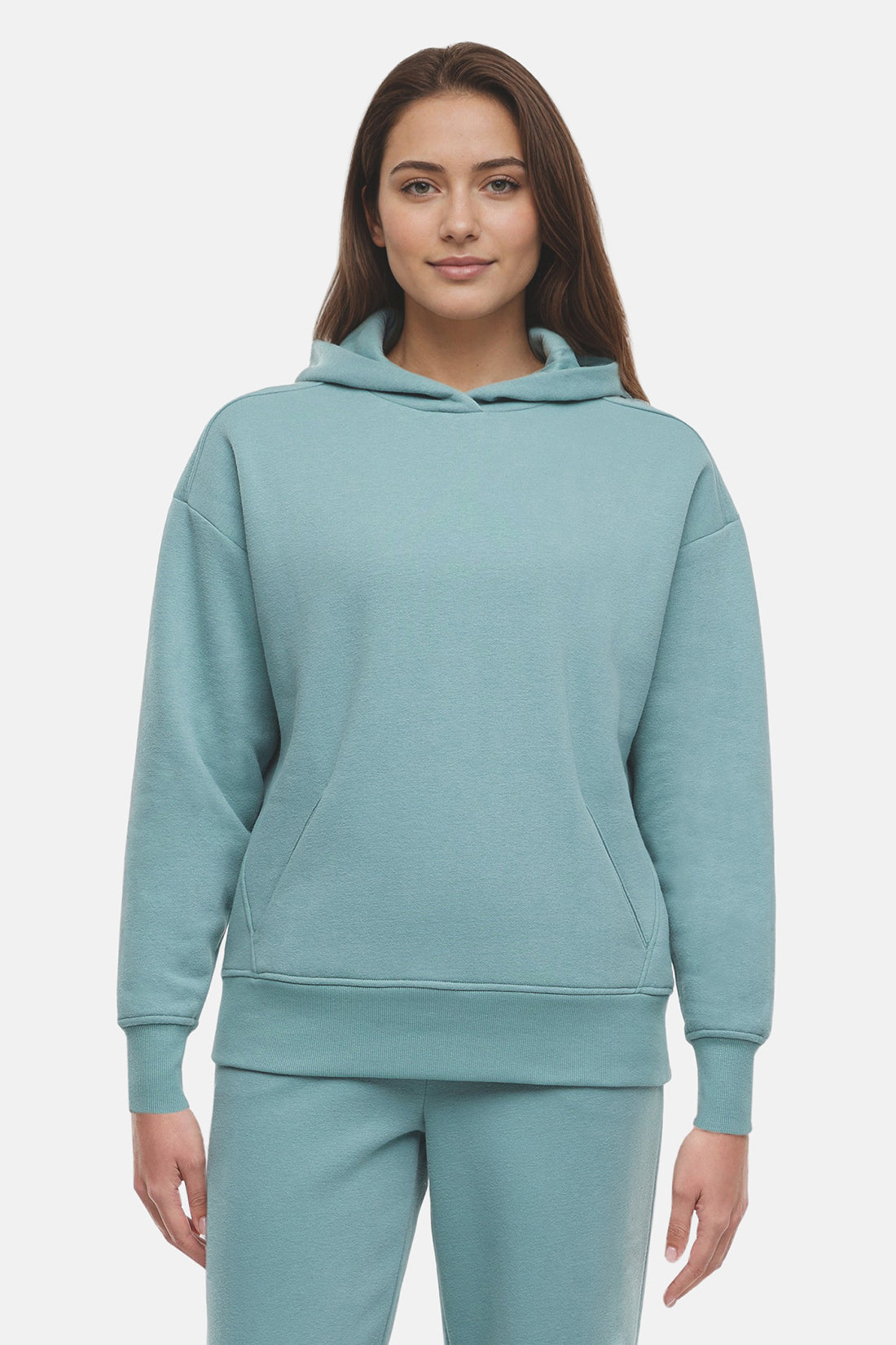 Woman wearing a light teal hoodie and pants on a white background