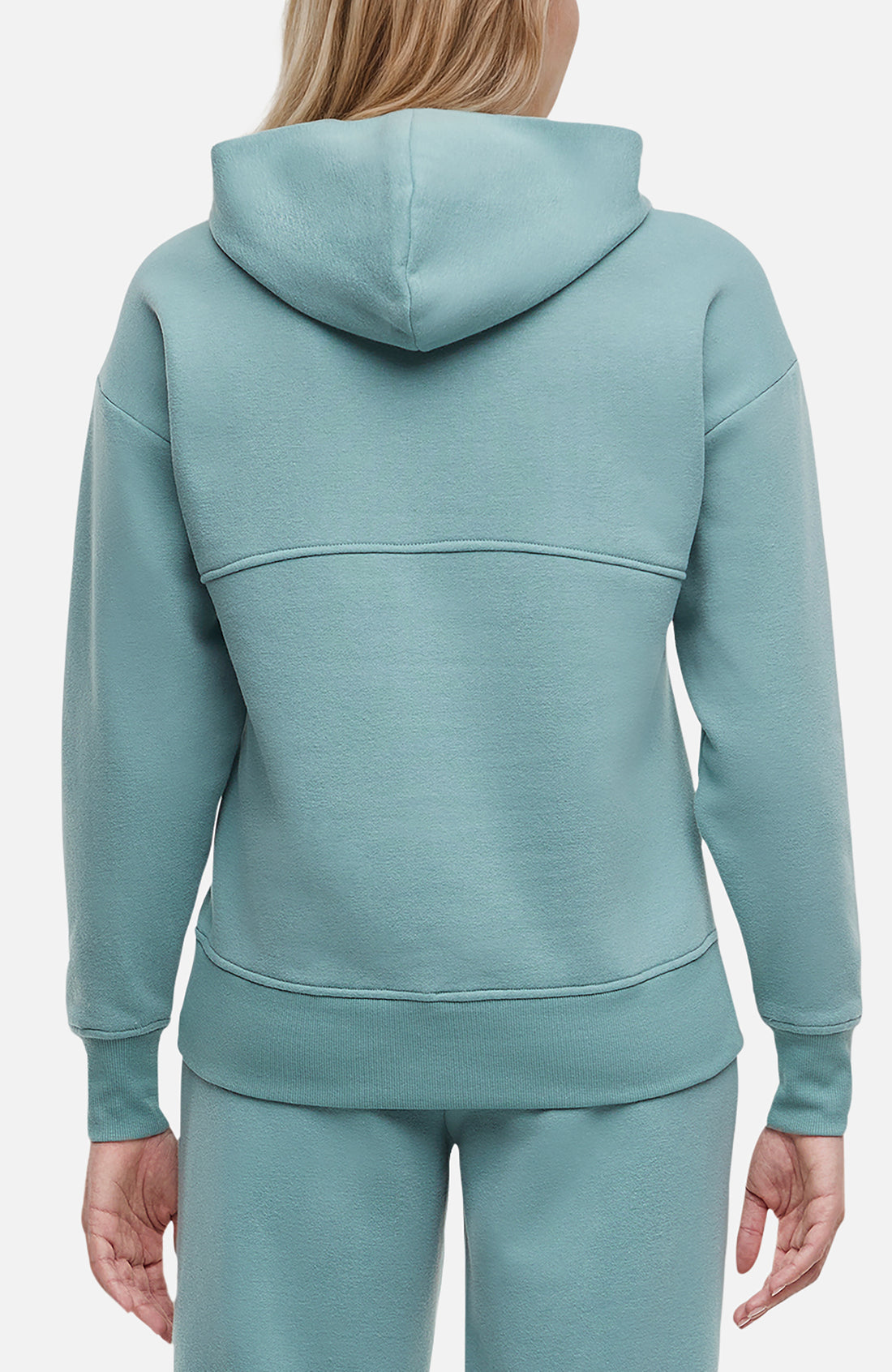 Back of woman wearing a light teal hoodie and pants on a white background