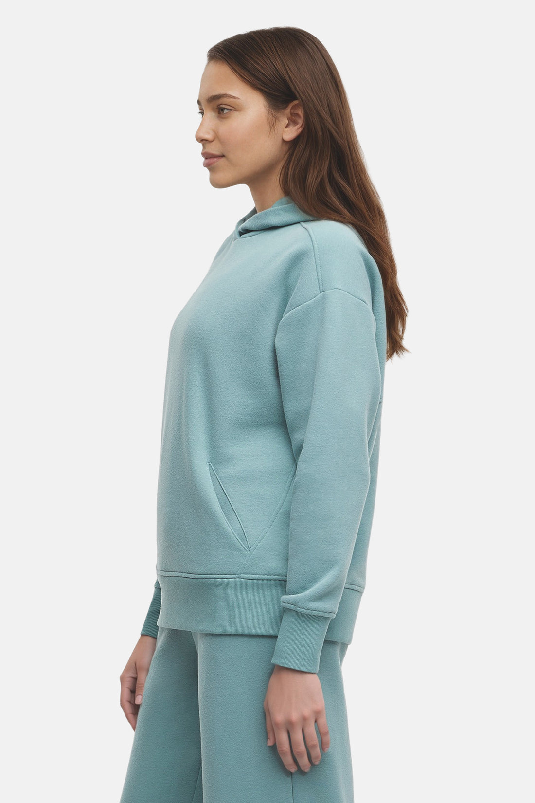 Woman wearing a light teal hoodie and pants on a white background