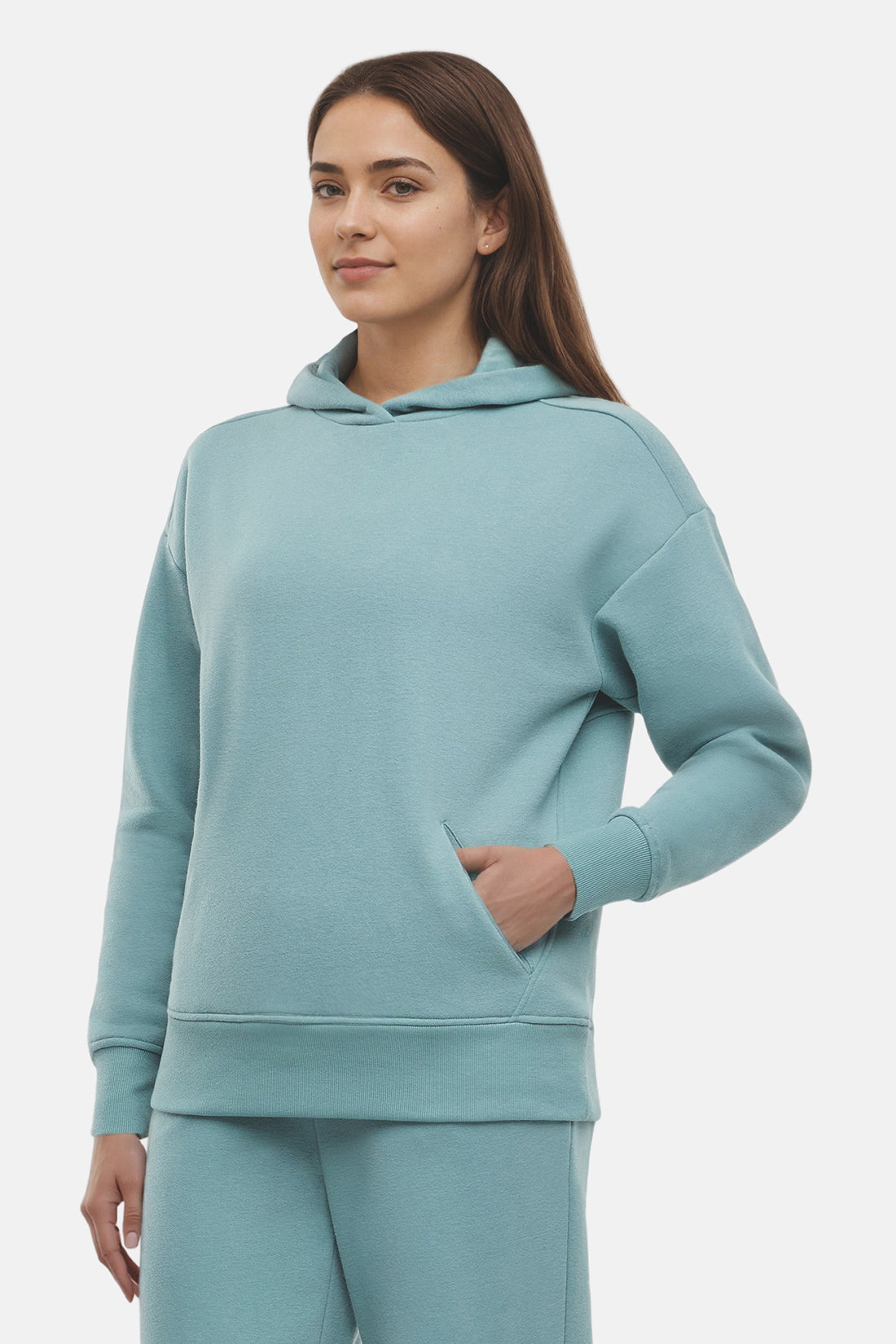 Woman wearing a light teal hoodie and pants on a white background
