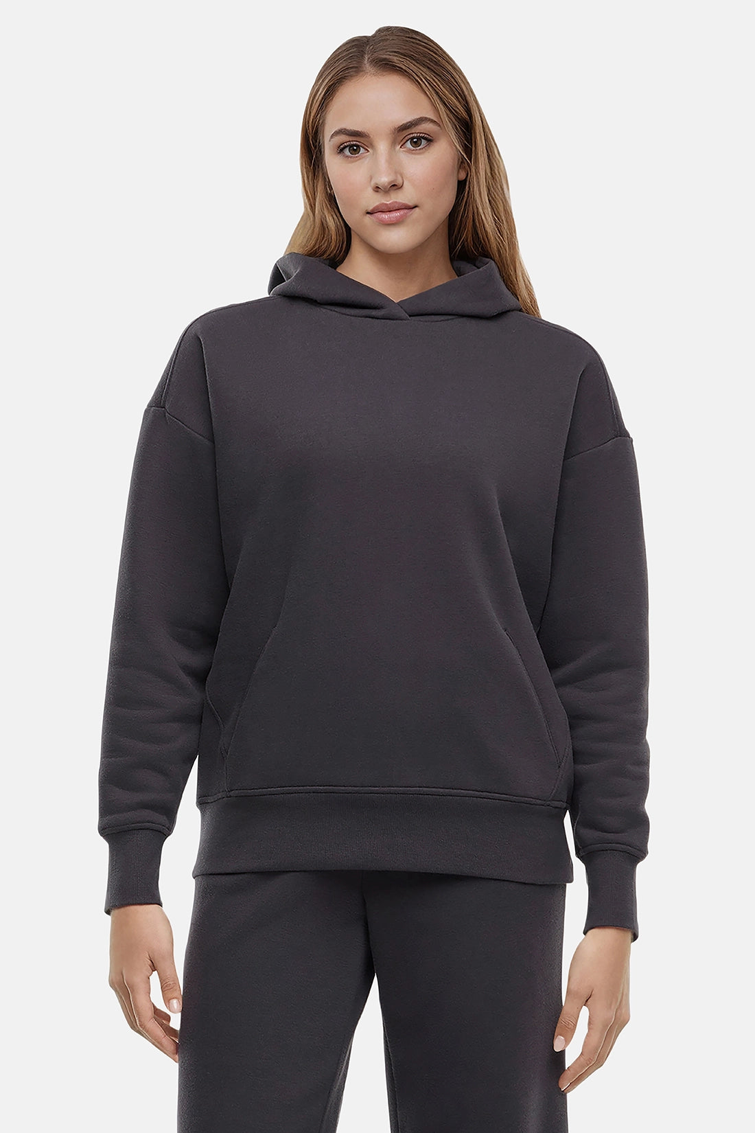 Woman wearing a dark gray hoodie on a light gray background