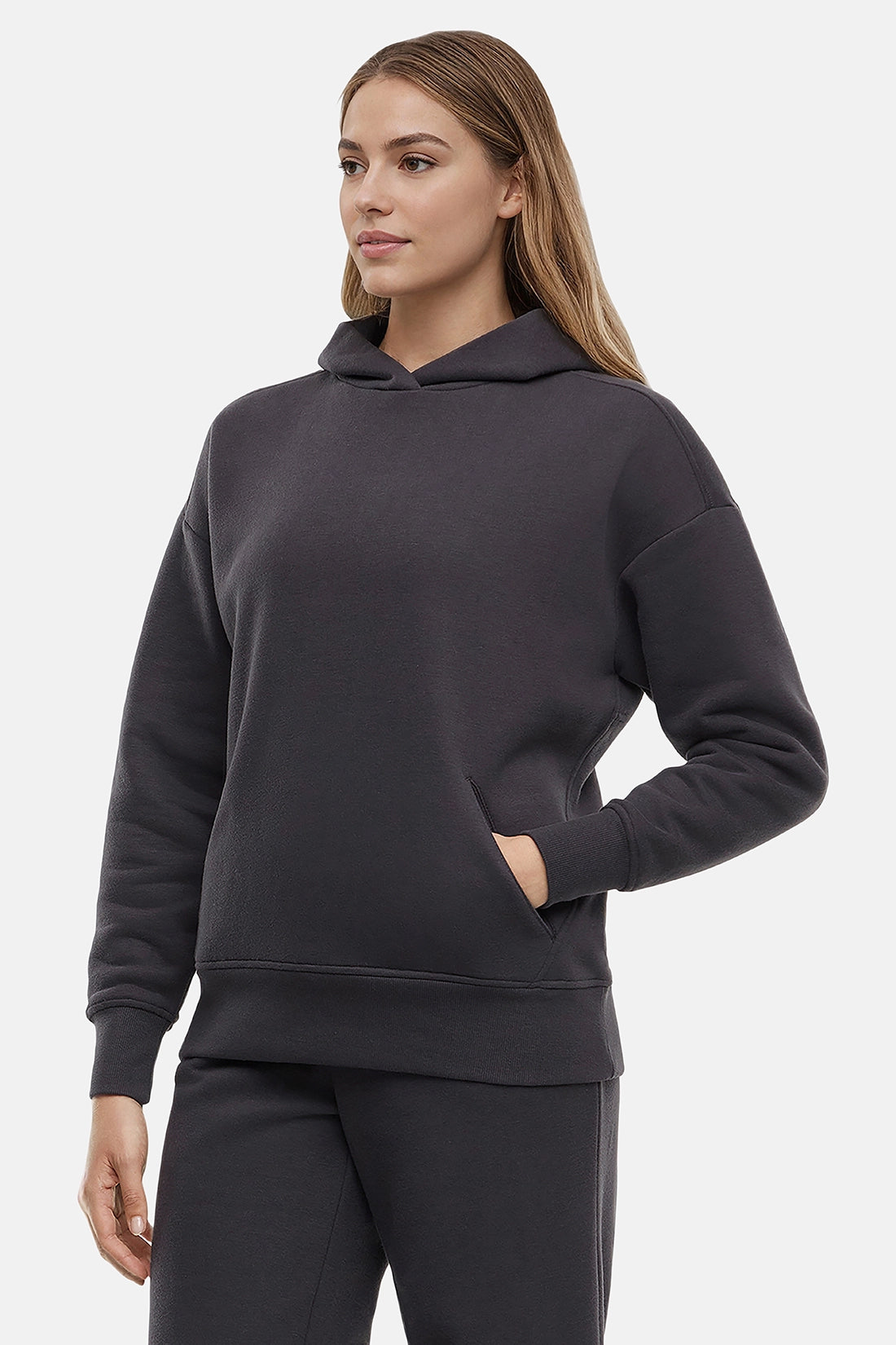 Woman wearing a dark gray hoodie on a light gray background