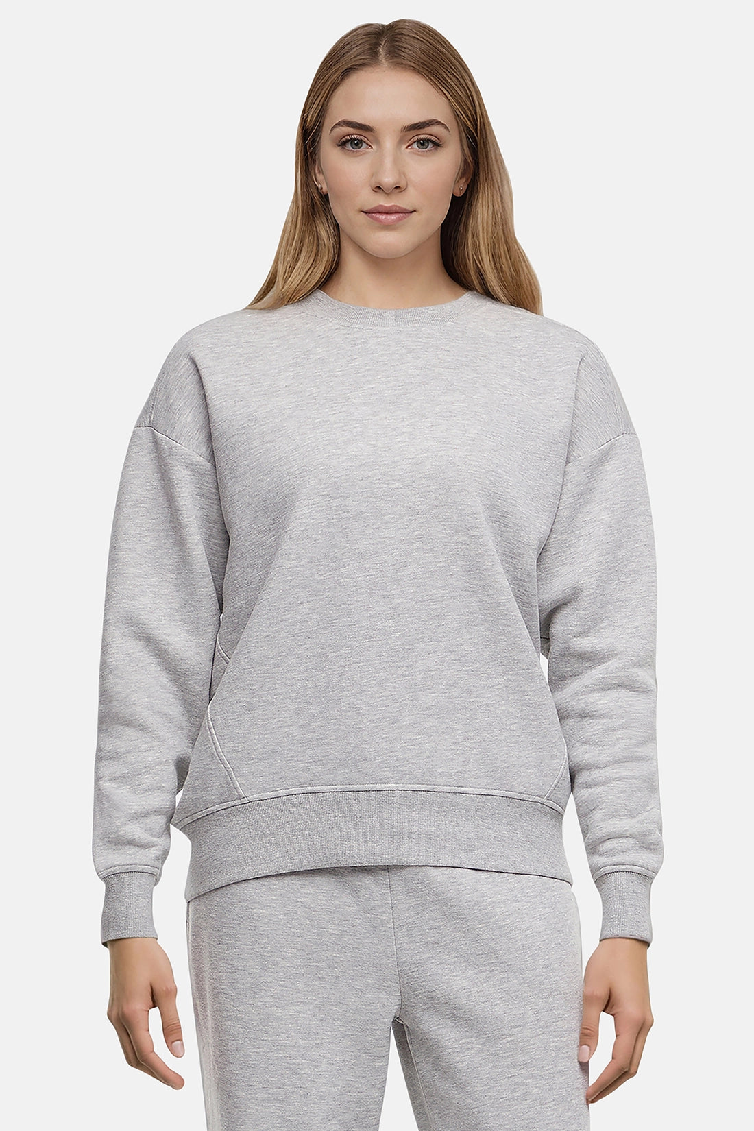 Woman wearing a heather gray sweatshirt and pants on a white background