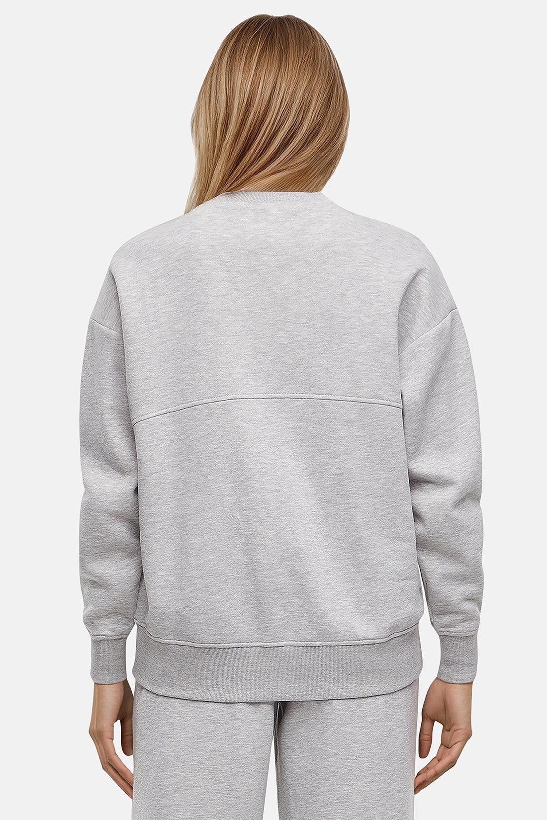 Back of woman wearing a heather gray sweatshirt and pants on a white background