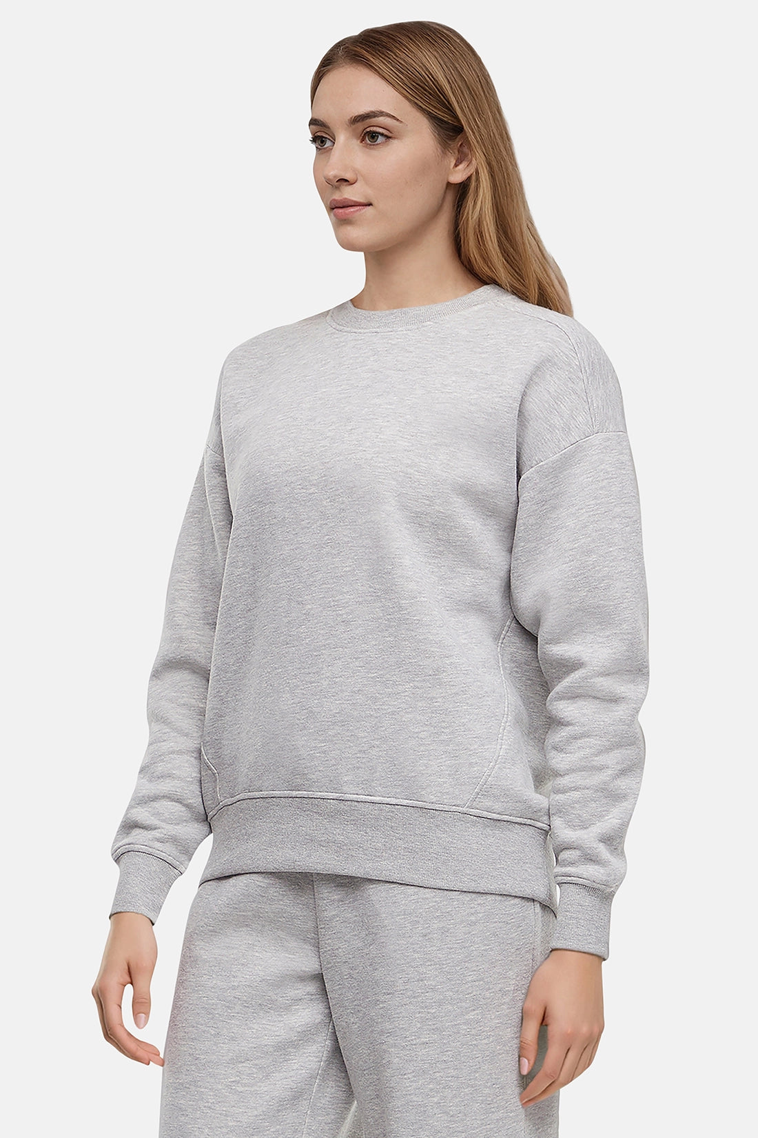 Woman wearing a heather gray sweatshirt and pants on a white background
