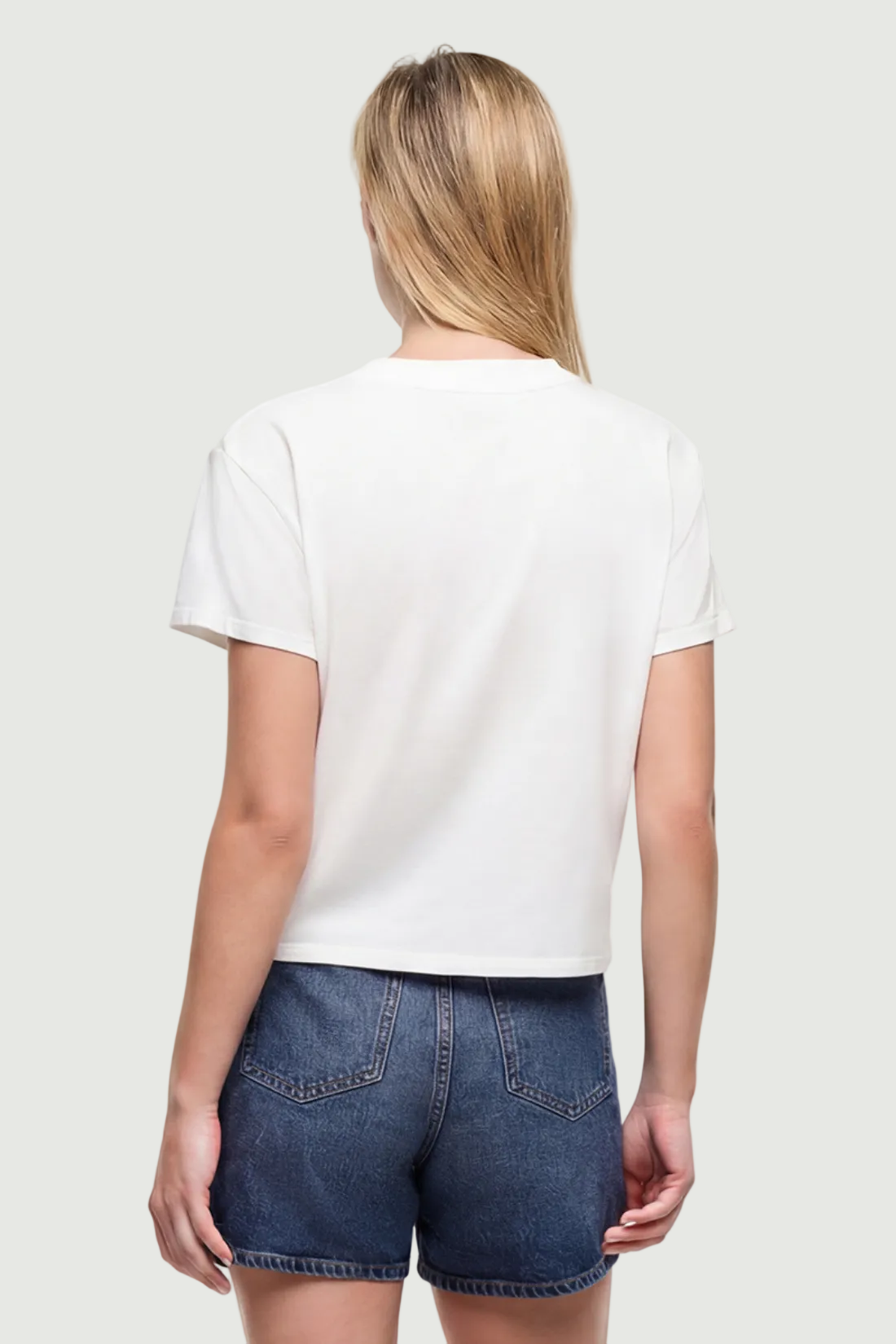 Back view of woman wearing a white t-shirt on a white background.