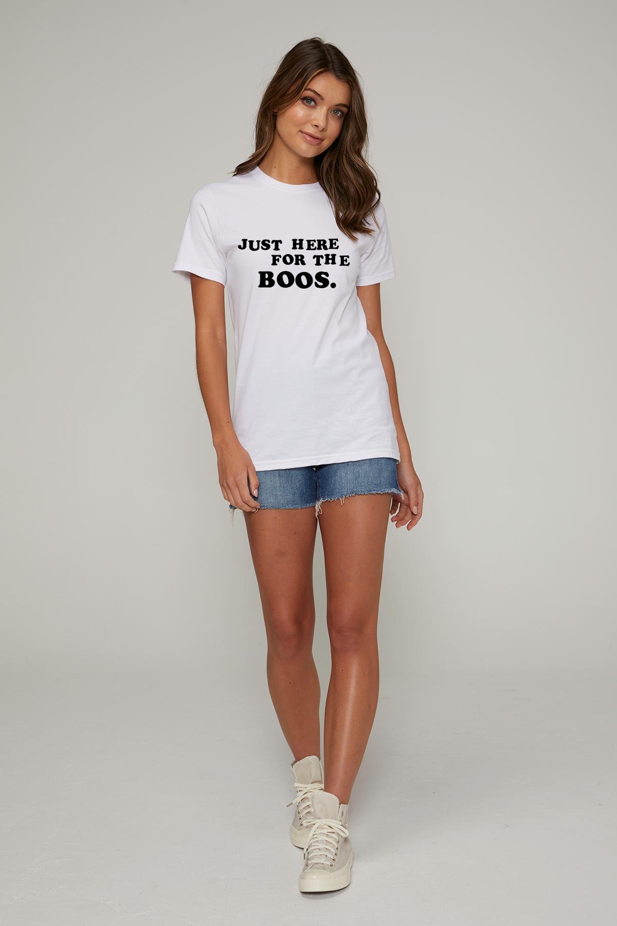 A woman wearing a white crew neck t-shirt with the text &