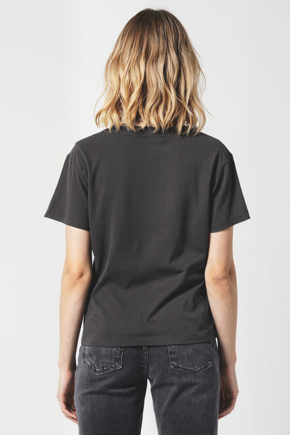 Woman wearing a black t-shirt and dark jeans on a white background