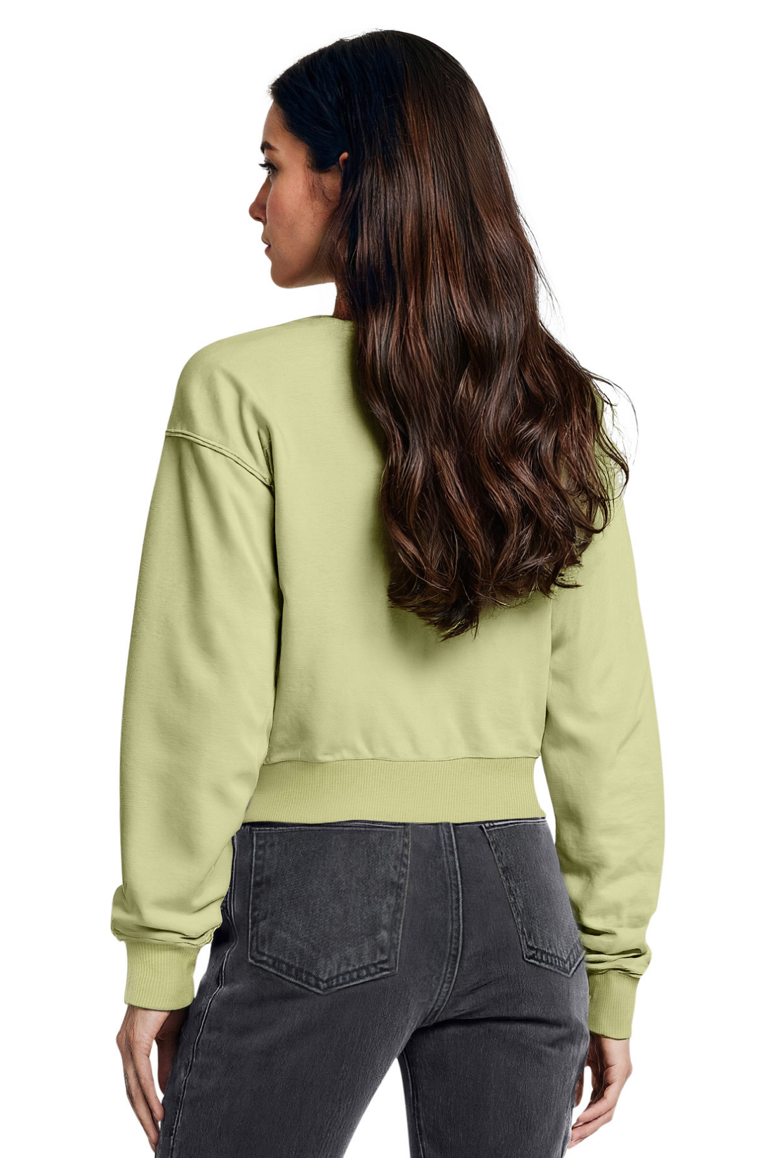 Woman wearing a light green sweatshirt and dark jeans on a white background