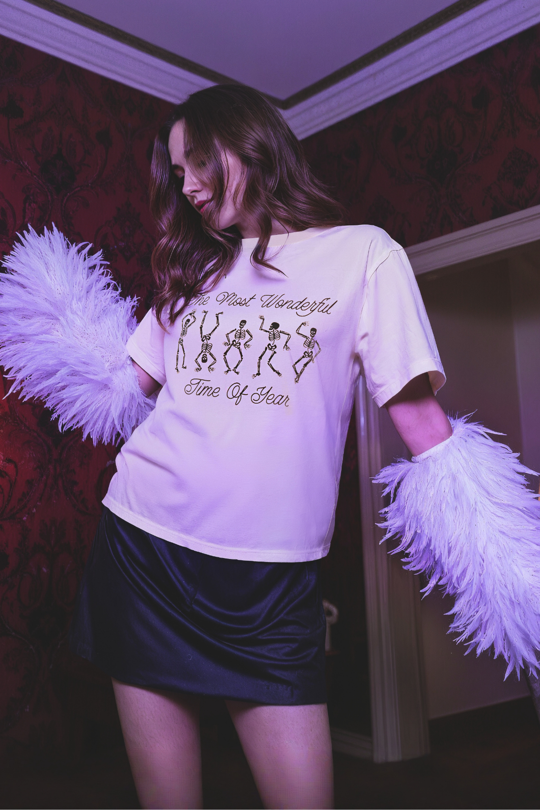 Woman wearing a pink t-shirt with skeleton dancing design and text &