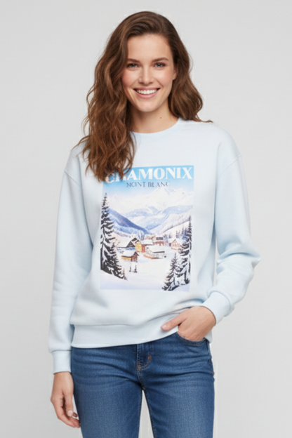 Woman wearing a light blue sweatshirt with a mountain graphic and &
