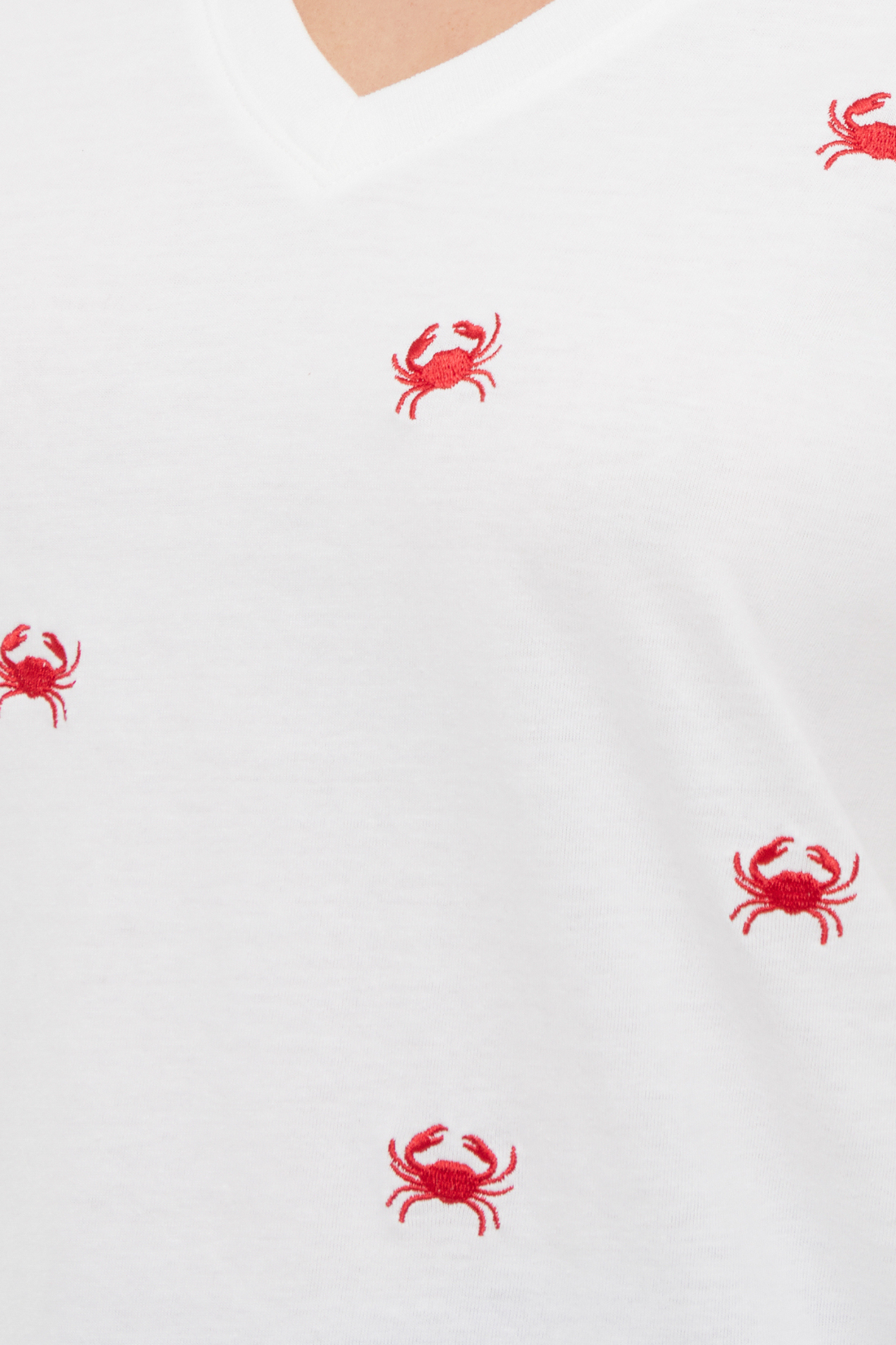 Close up of white t-shirt with red embroidered crab patterns 