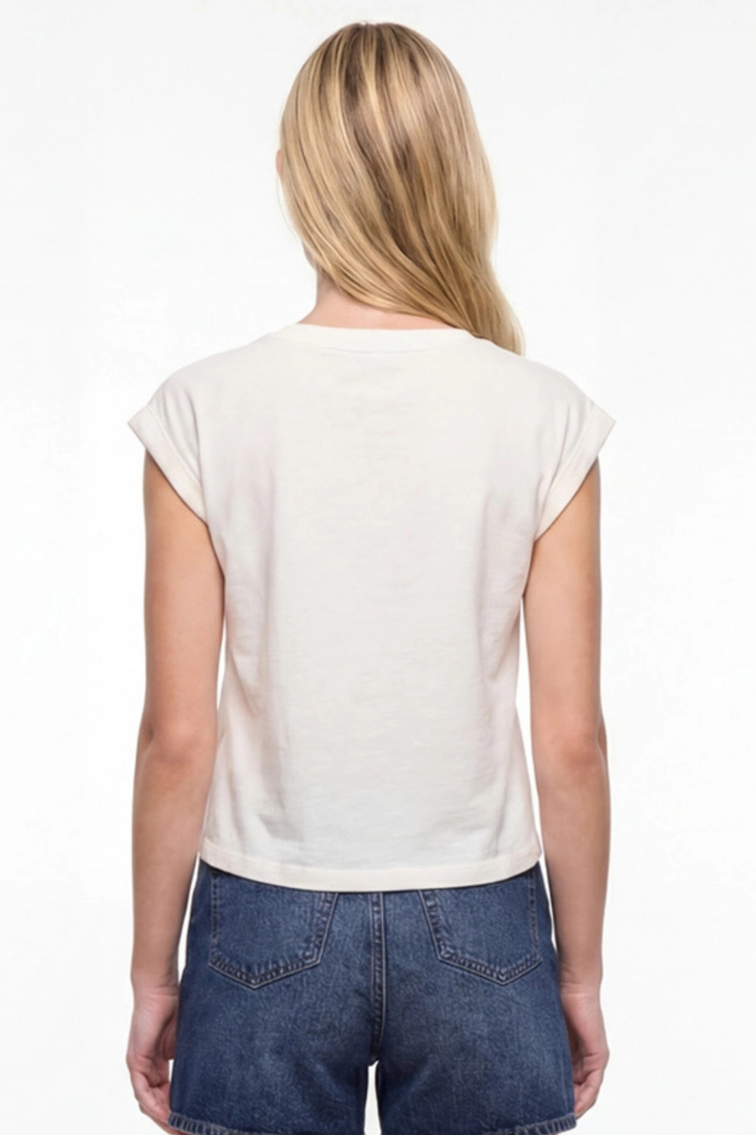 Back view of woman wearing a white cap sleeve tee and blue jeans shorts on a white background. 