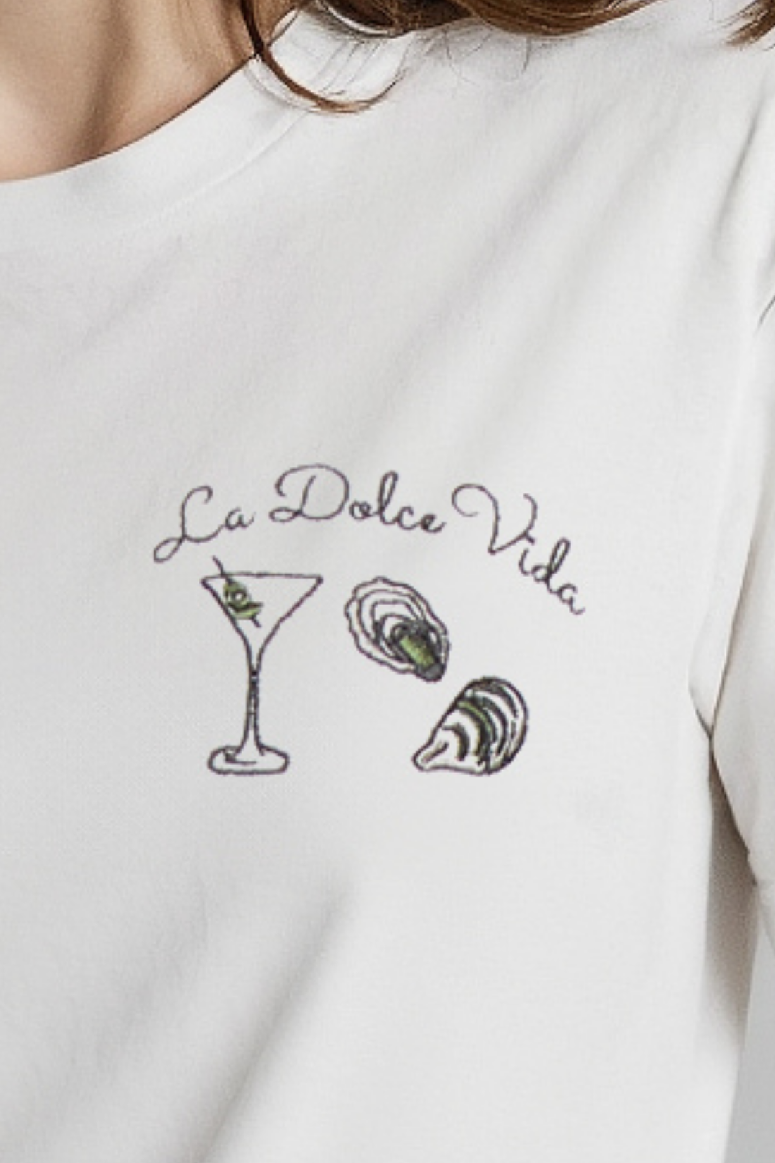 A woman wearing a white crop tee with the text &