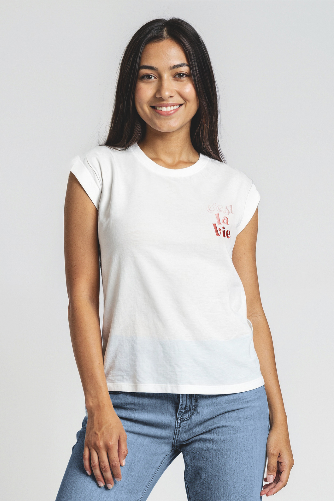 Woman wearing a white t-shirt with pink/red "Cest La Vie" text on a plain background