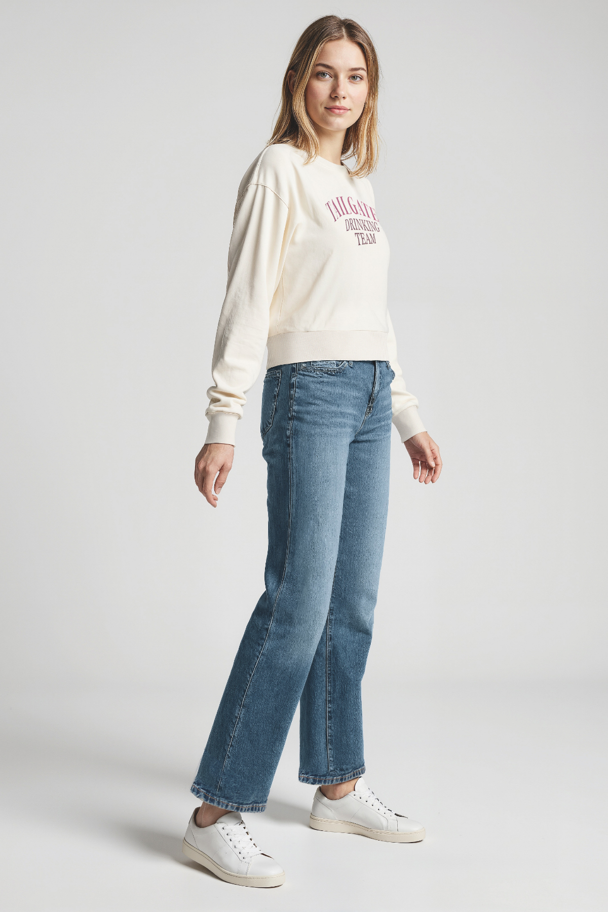 Woman wearing a white sweatshirt with &