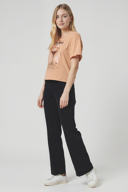 Woman wearing a tan t-shirt with a &quot;Pumpkin Spice Martini&quot; text and pumpkin spice martini graphic on a plain background